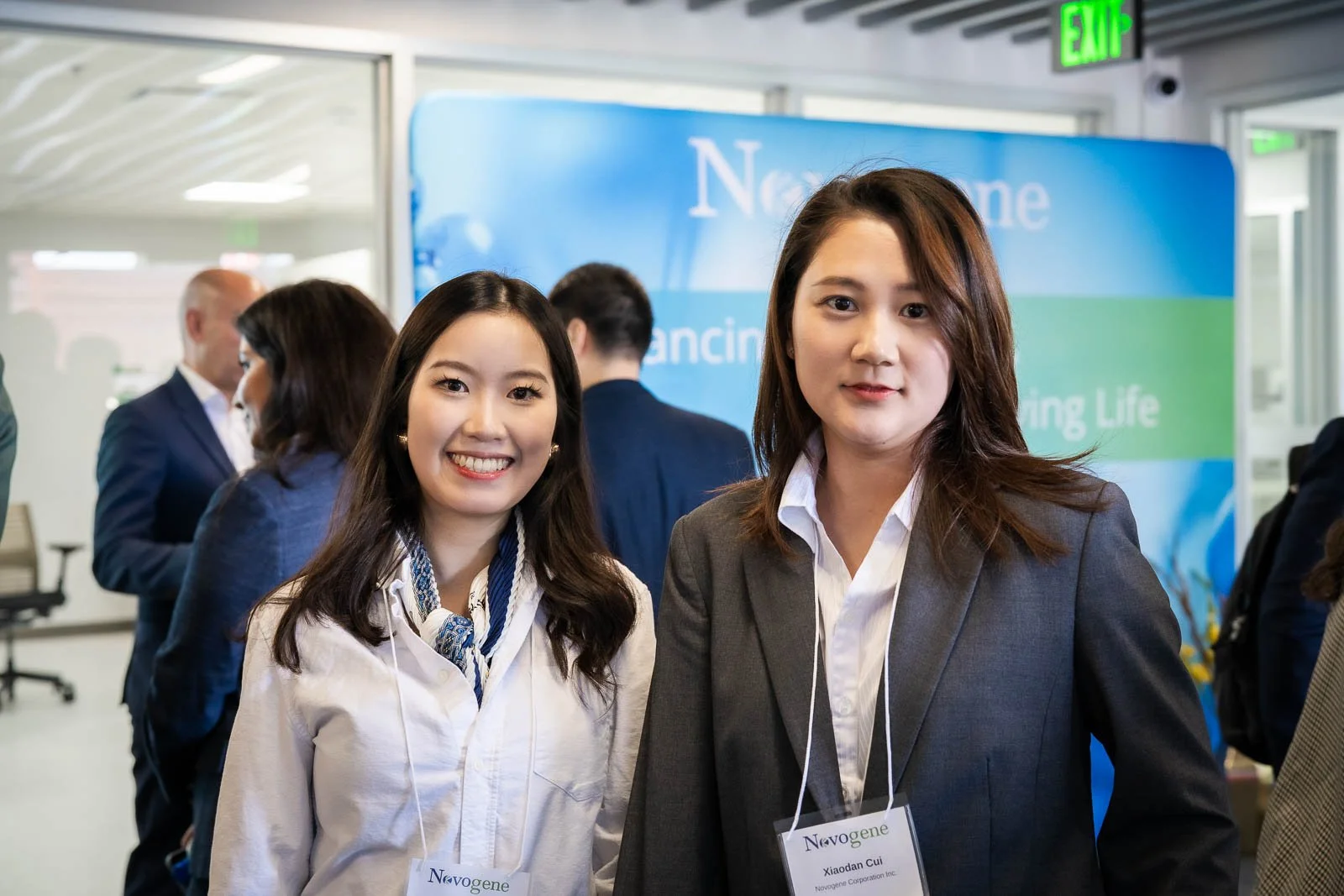 Event photography of two smiling women at the ribbon cutting for Novogene