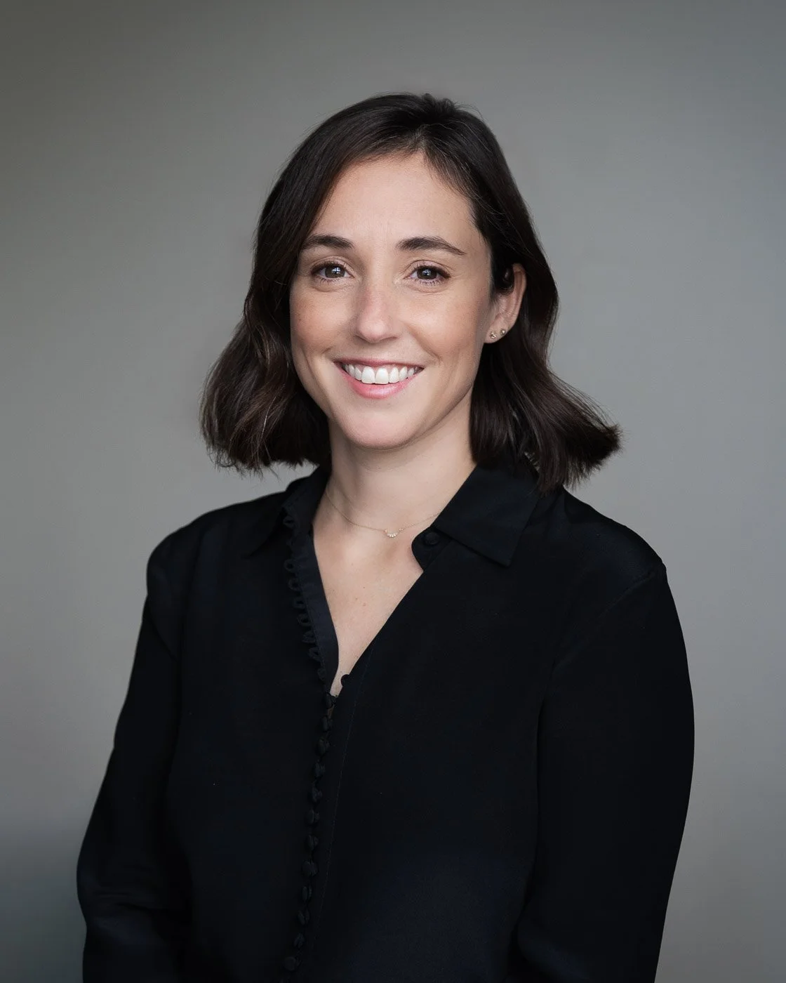 Studio headshot of a woman wearing all black