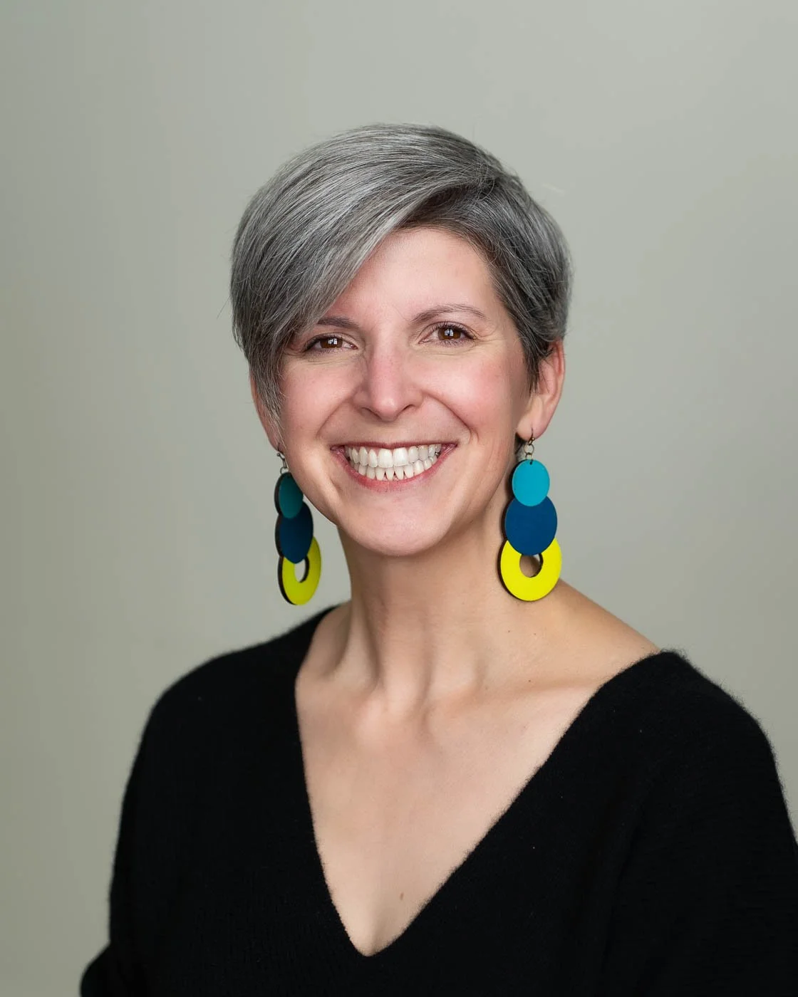 Headshot studio portrait of a woman with colorful earings