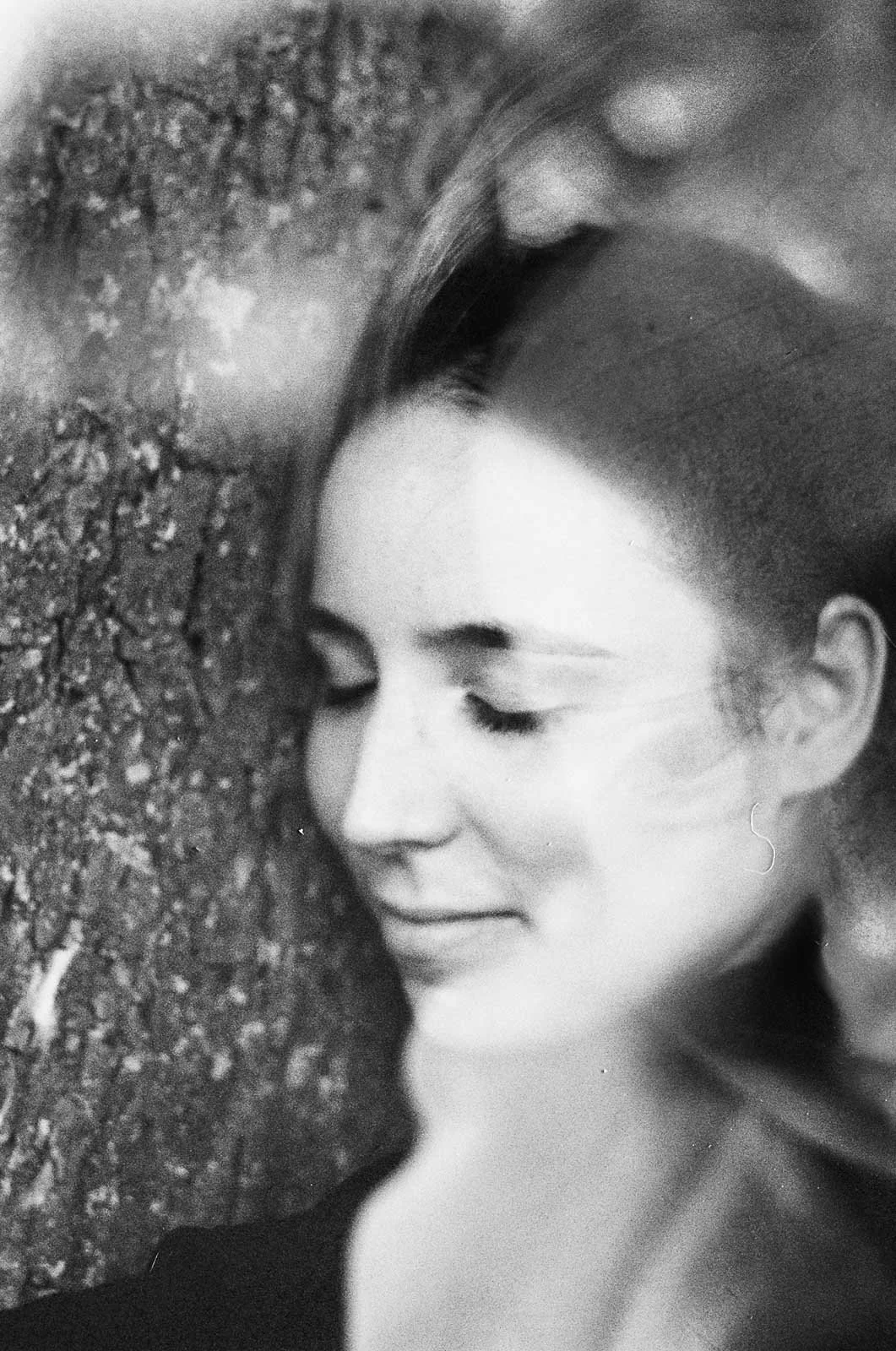 A smiling girl hugging a tree