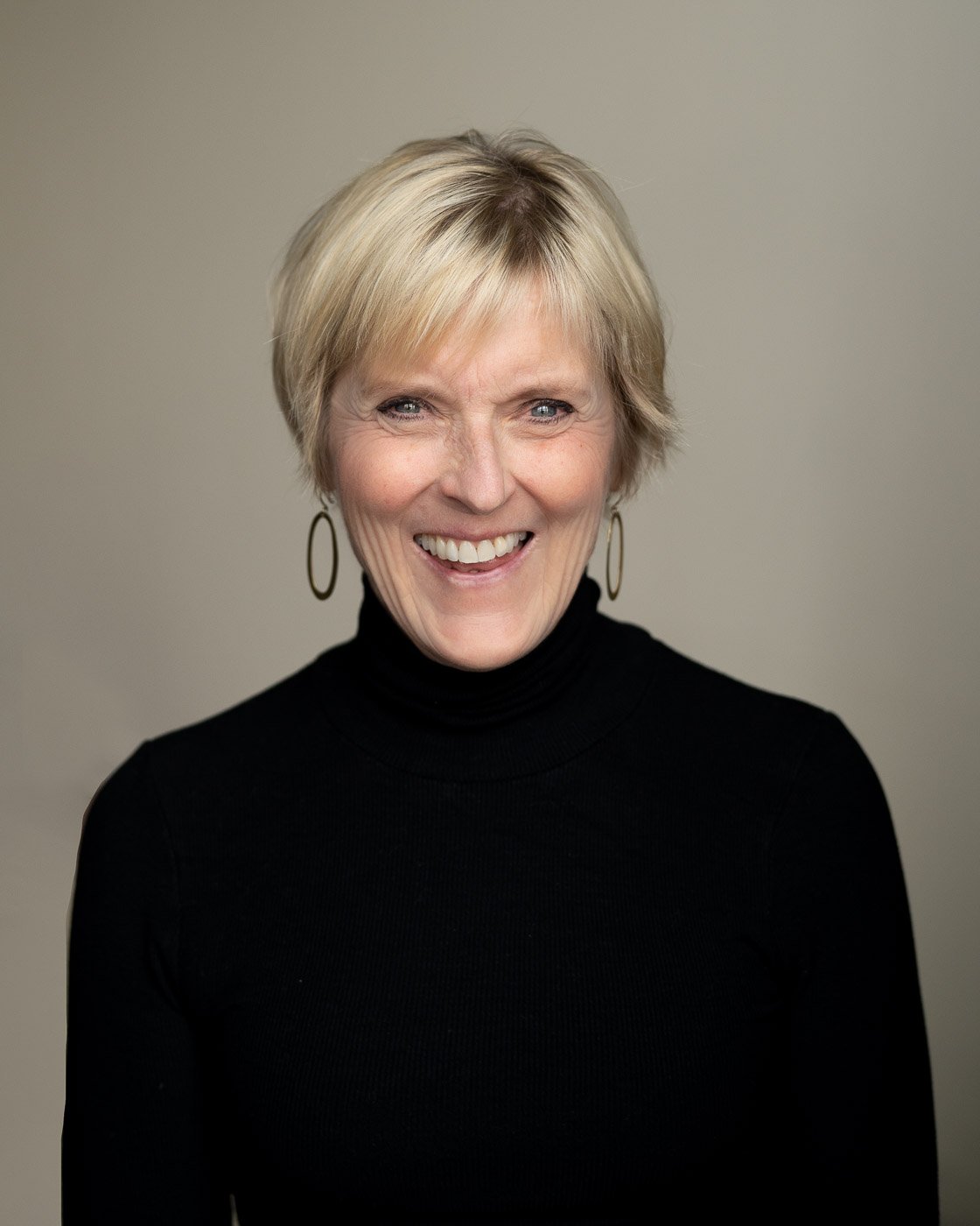 Studio headshot of a woman in a black turtleneck