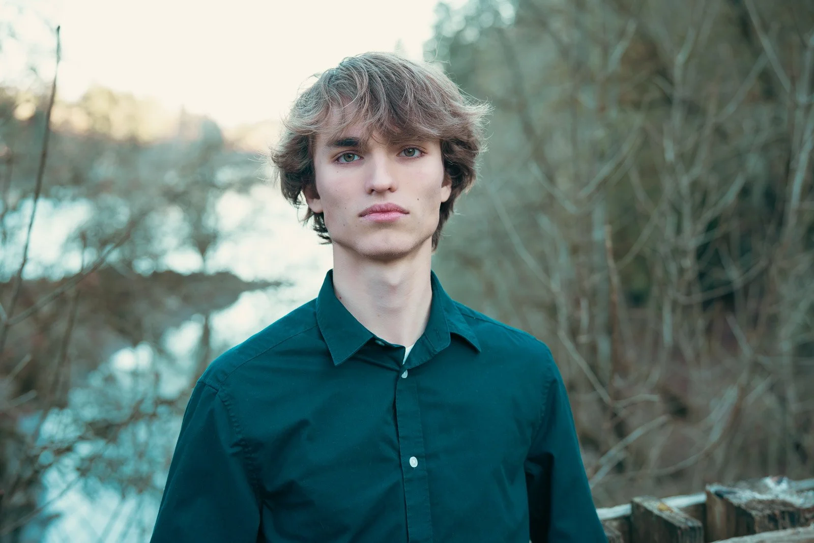 High school senior boy poses in front of a river at George Rodgers Park