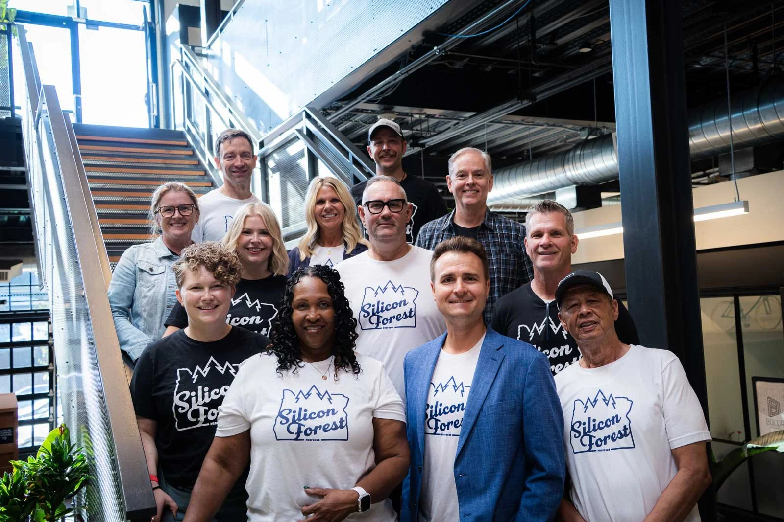 A group of people wearing matching "Silicon Forest" shirts on the stairs of Kiln