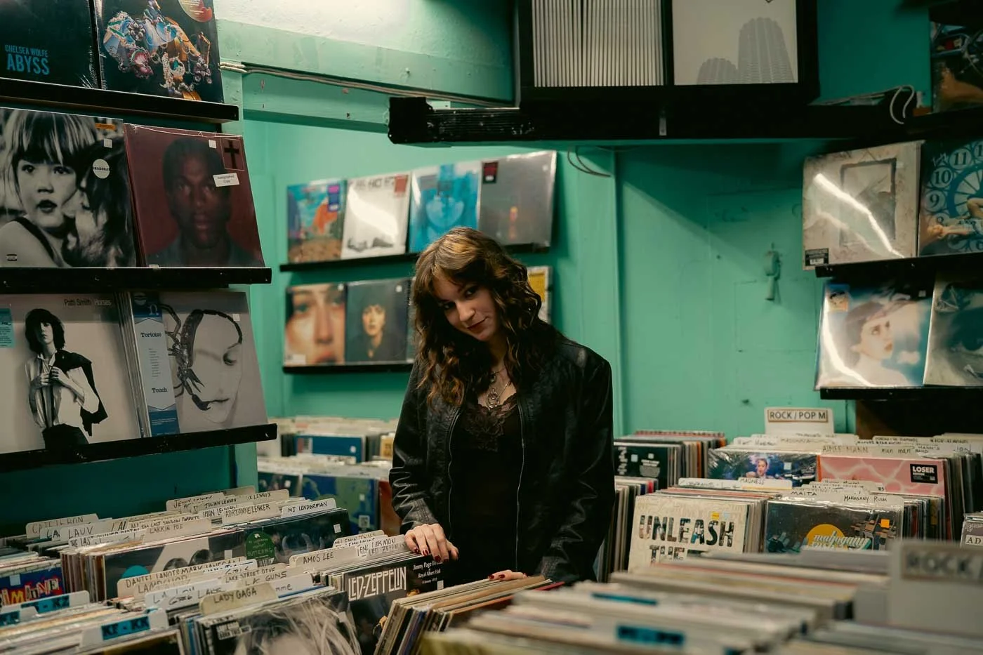 A girl looking through records in a green room at Music Millenium