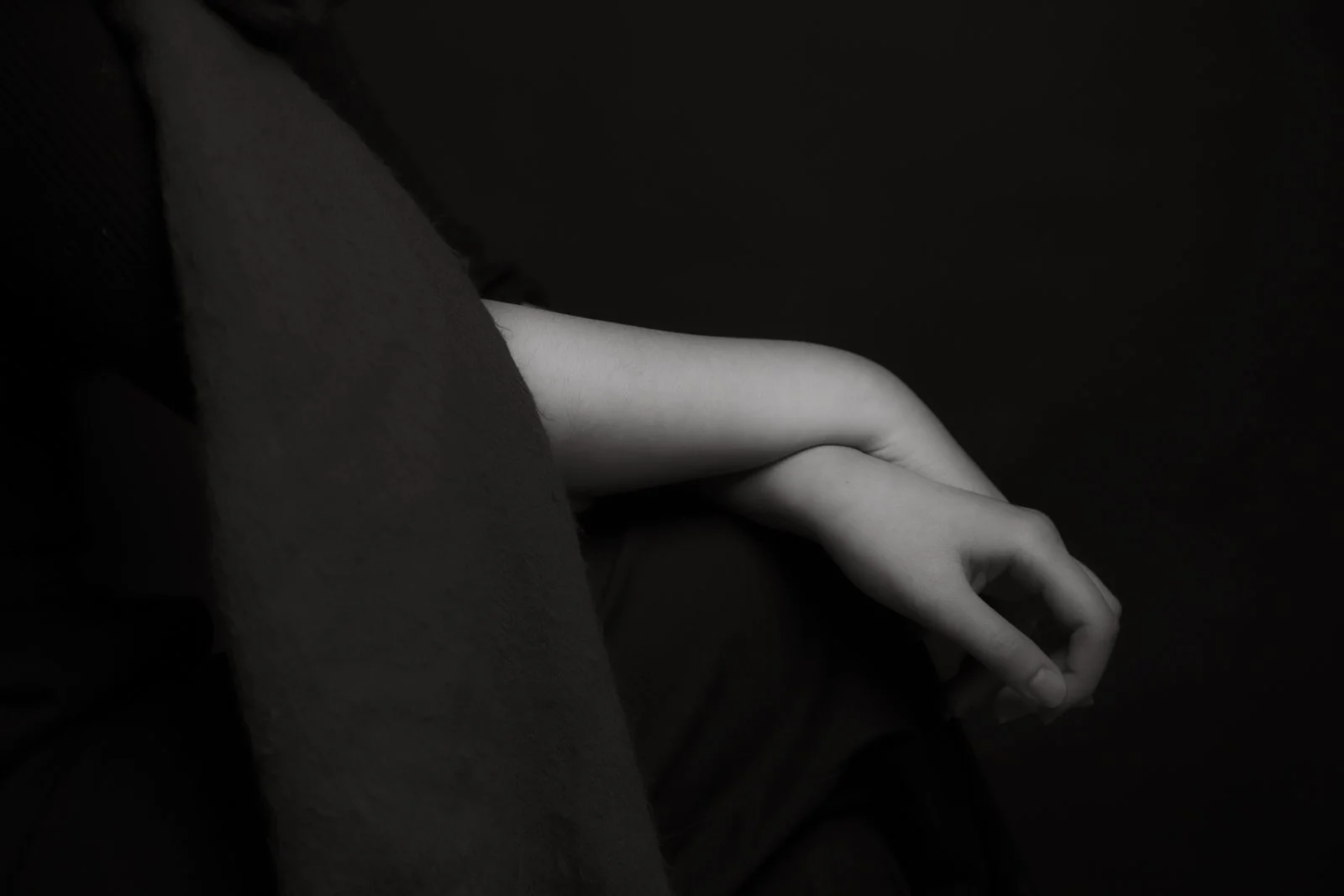 A persons hands elegantly crossed at the wrist