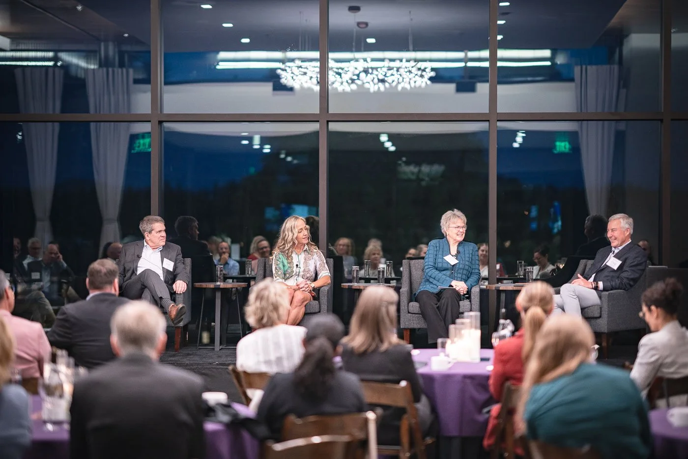 Laurie Baedke and discussion panel presenters in front of a crowd