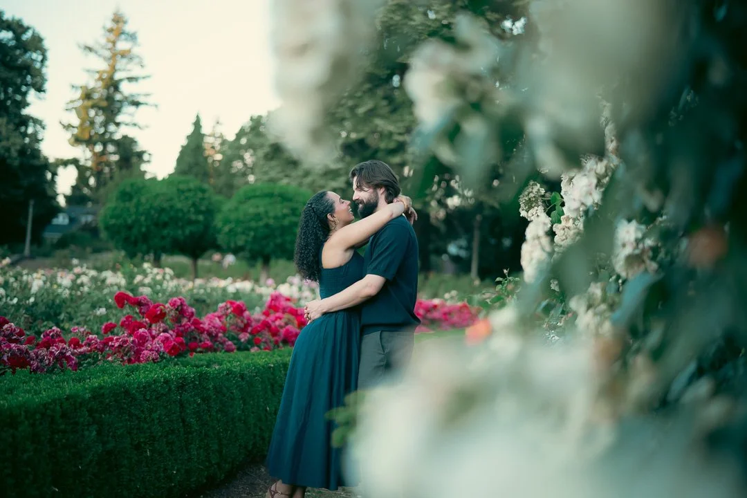 Interracial couple smiling in a rose garden