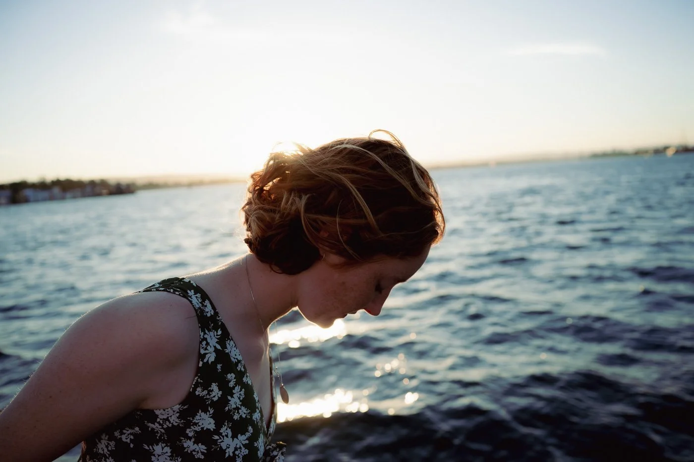 A girl leaning out from a sailboat over the river