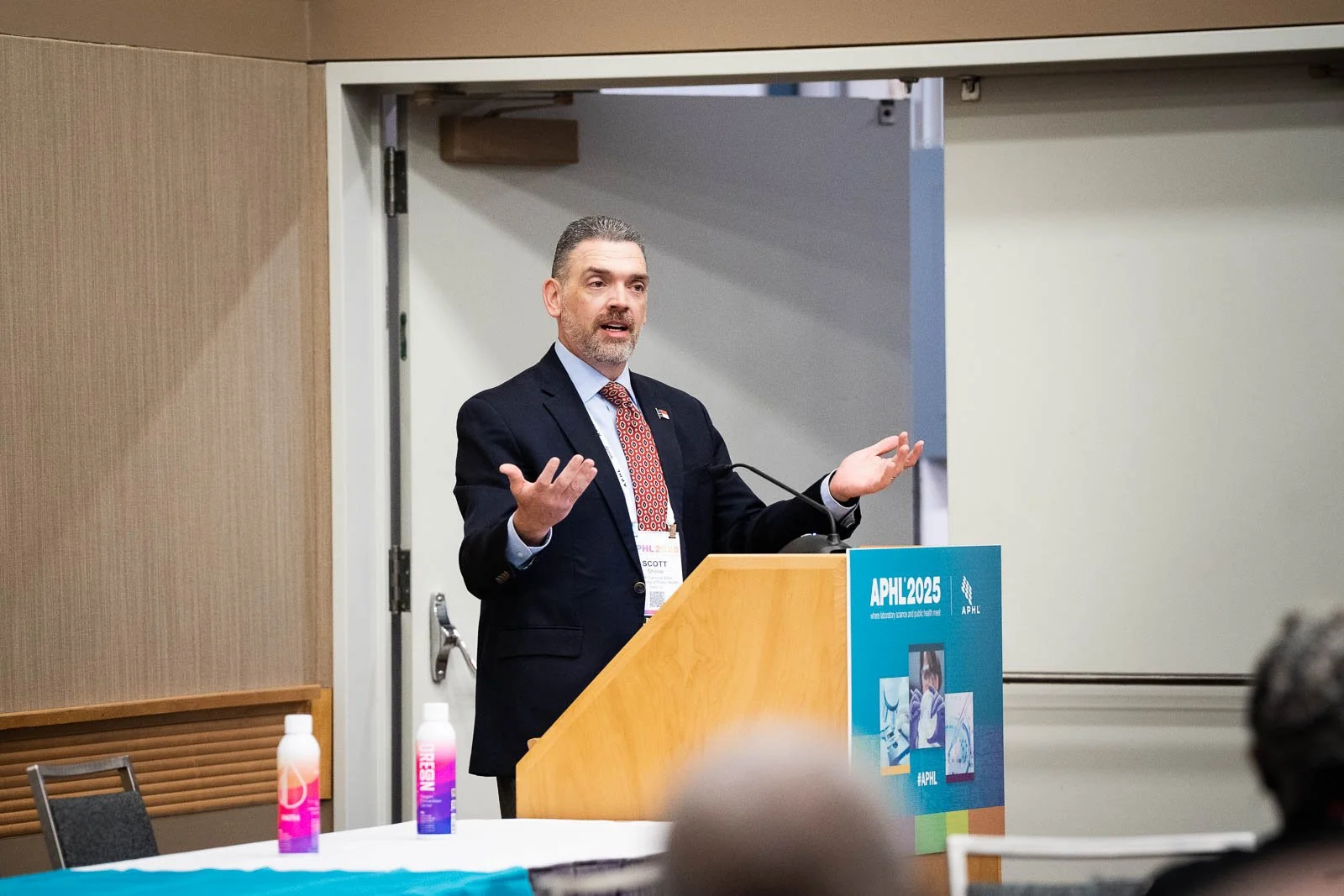 A man delivering a presentation with gesturing arms