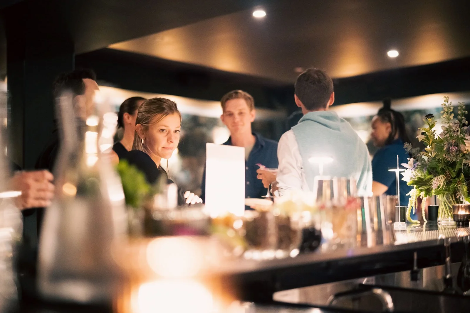 People standing talking at a bar for a work party