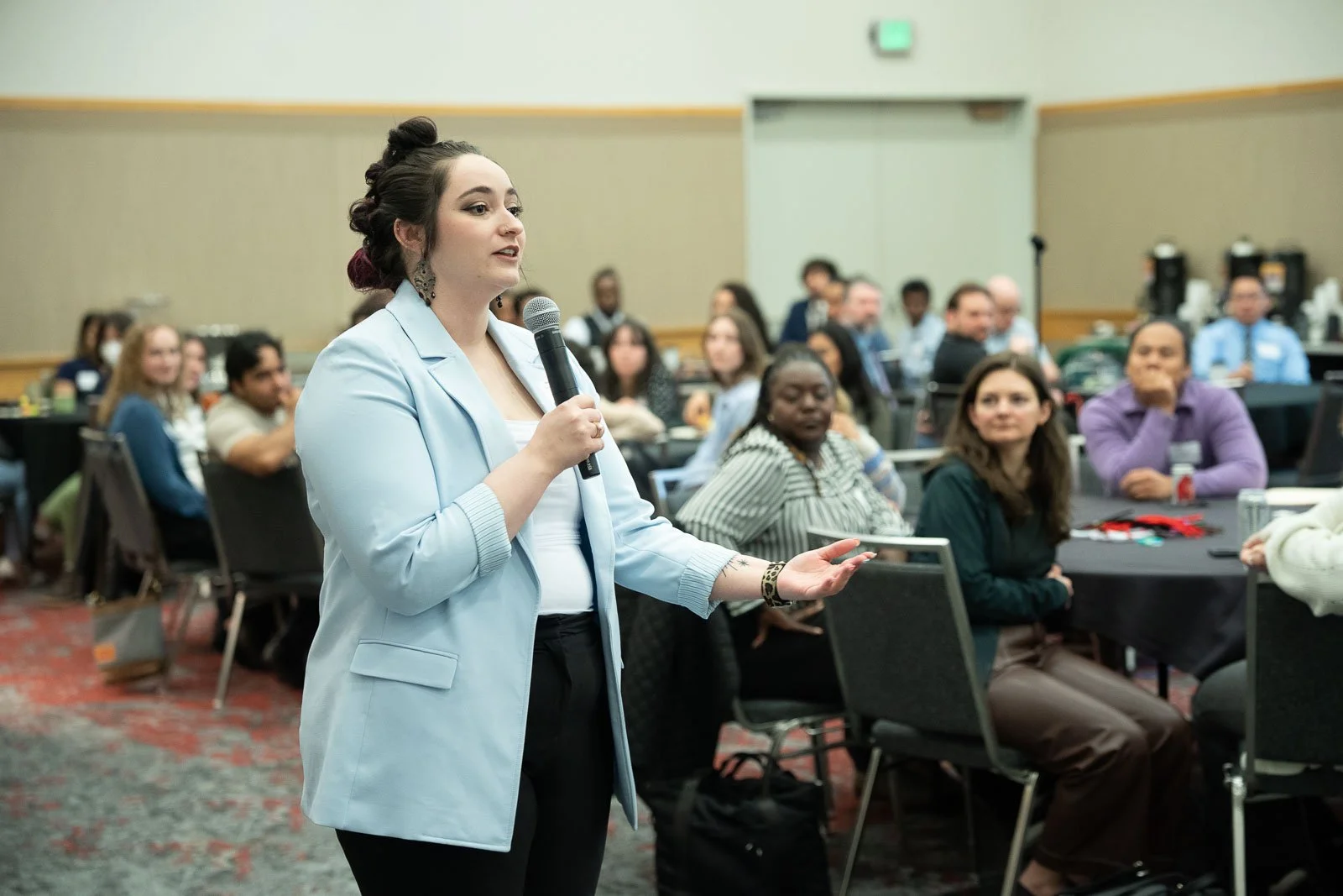 A woman asks a question in a conference hall at the APHL annual meeting
