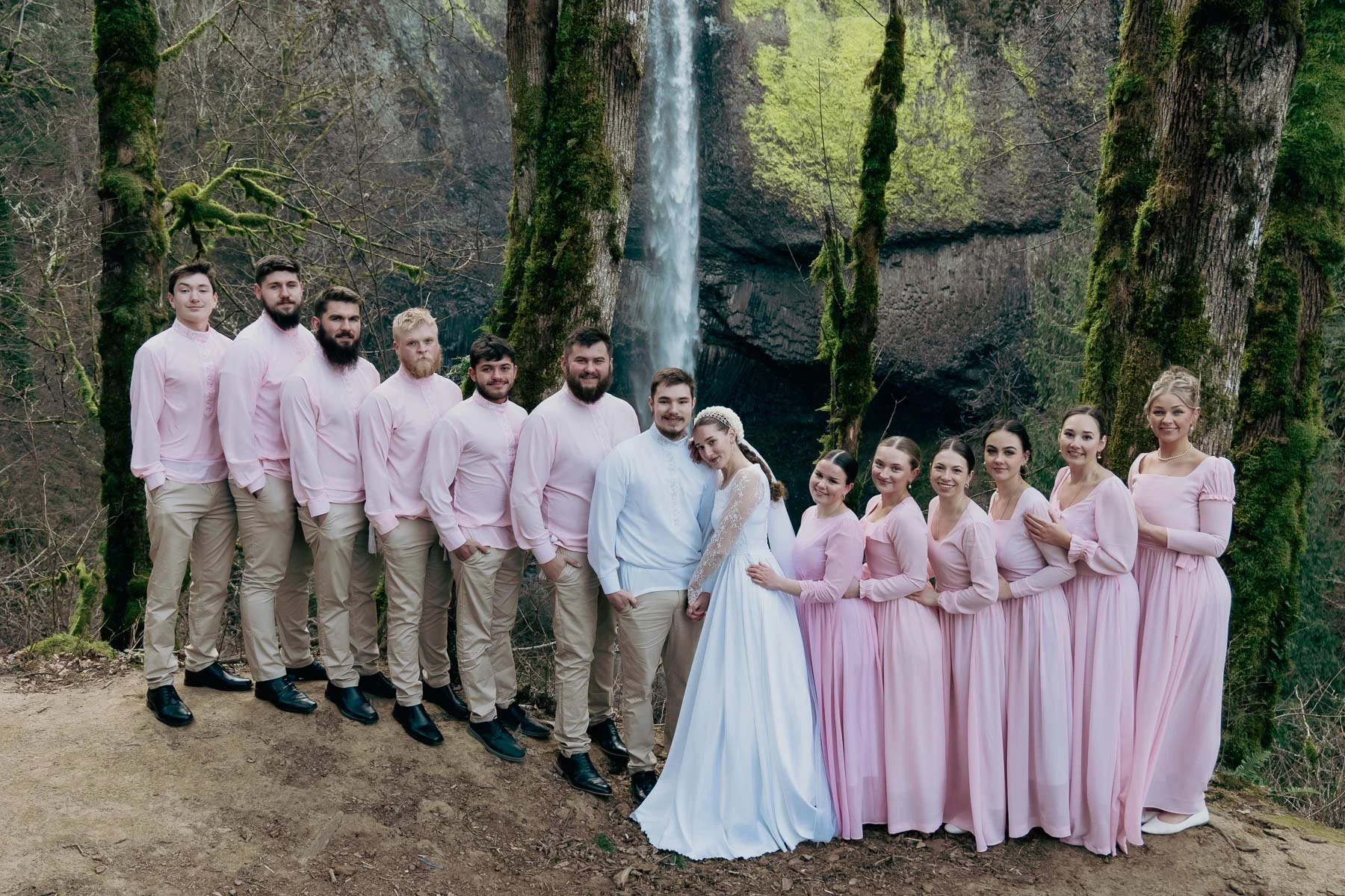 Matching bridal party in pink in front of a waterfall
