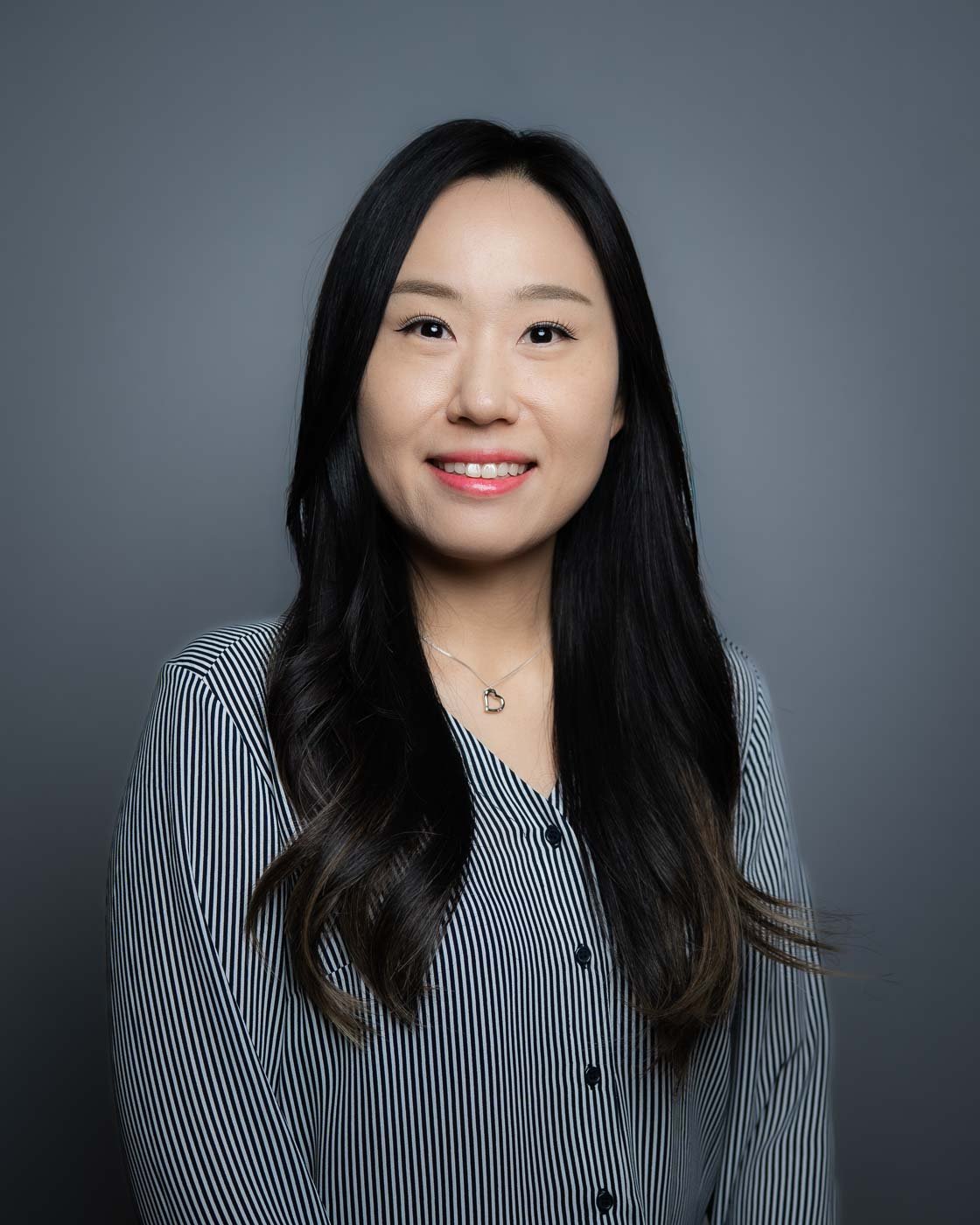 Headshot of a woman with a patterned grey shirt