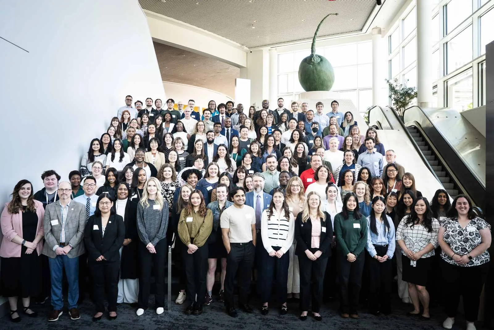 A large group of people pose for a photo on the stairs of the Portland Expo Center