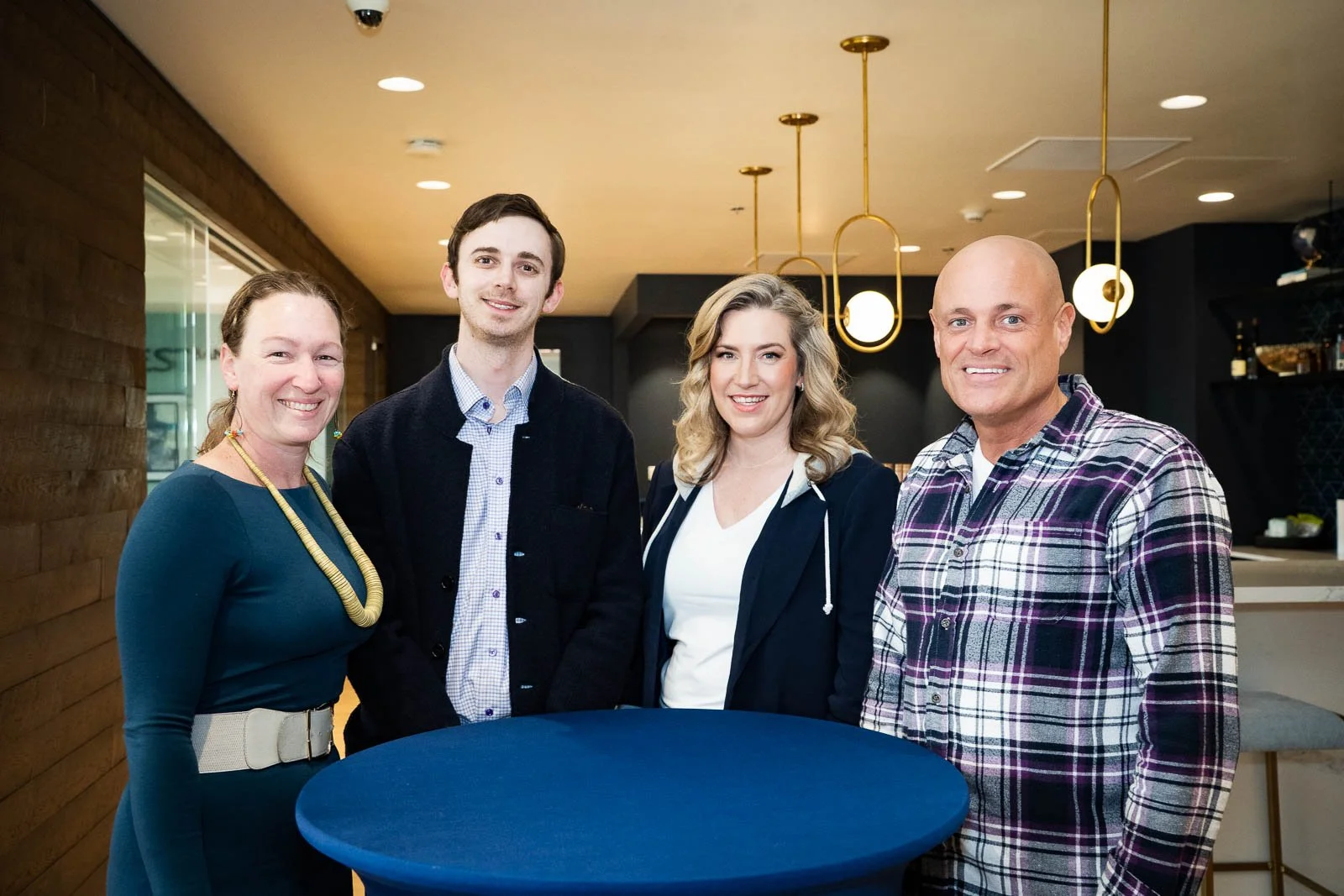 Smiling group of people around a table in a bank event space