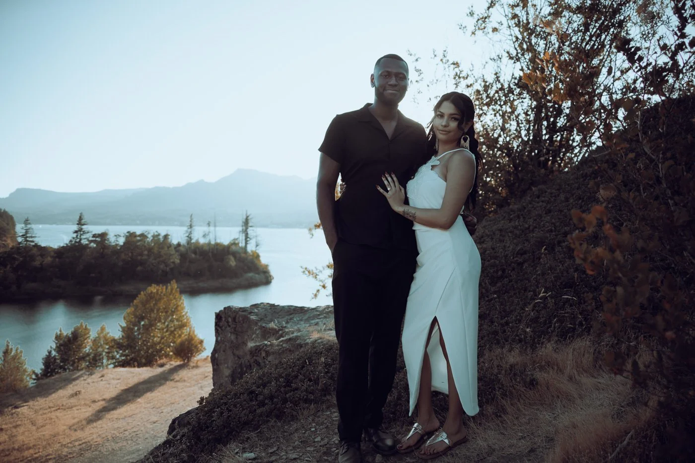 A engaged couple standing on the cliff formations along the Columbia River Gorge