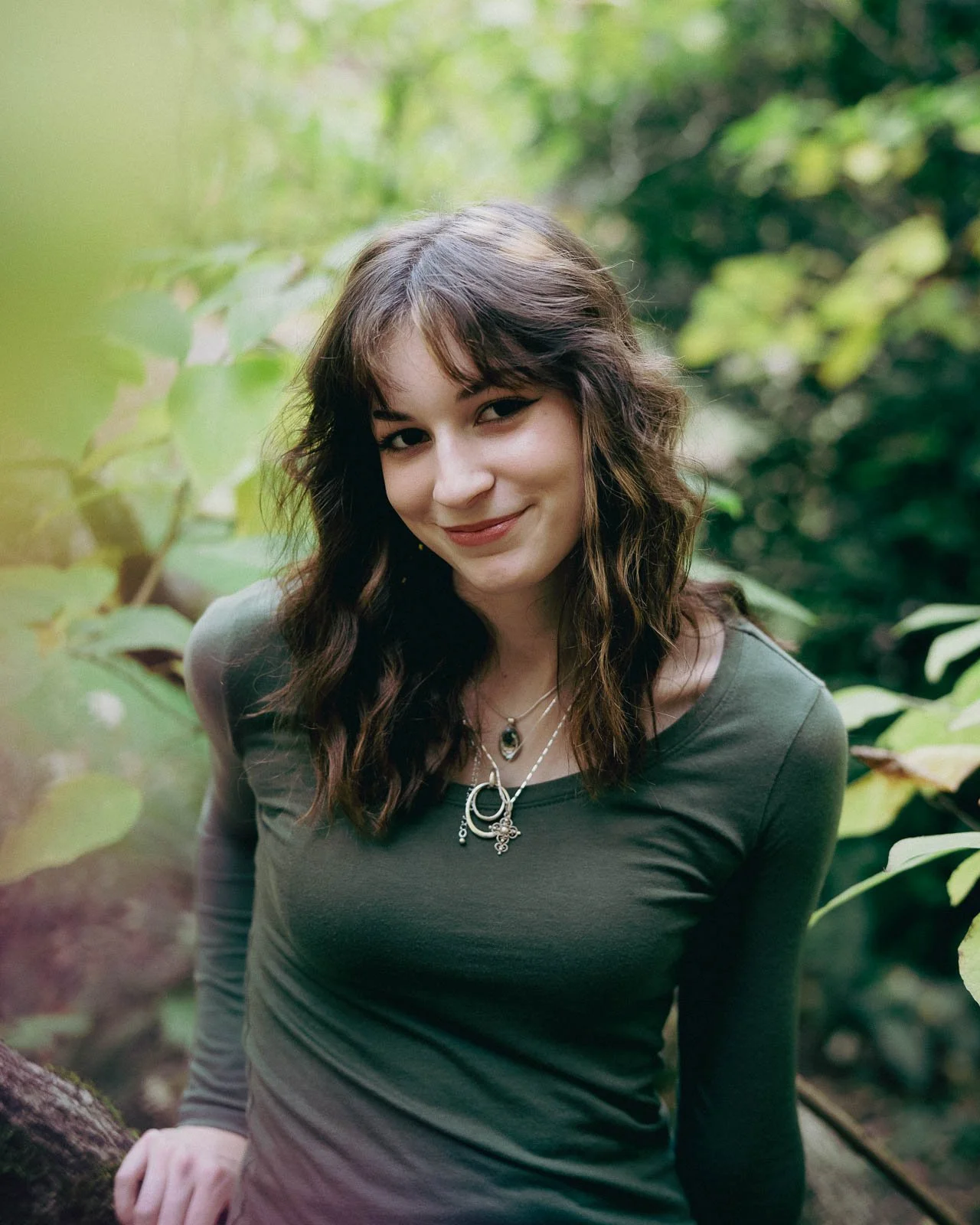 Close up portrait of a senior in Laurelhurst Park, surrounded by blurred nature