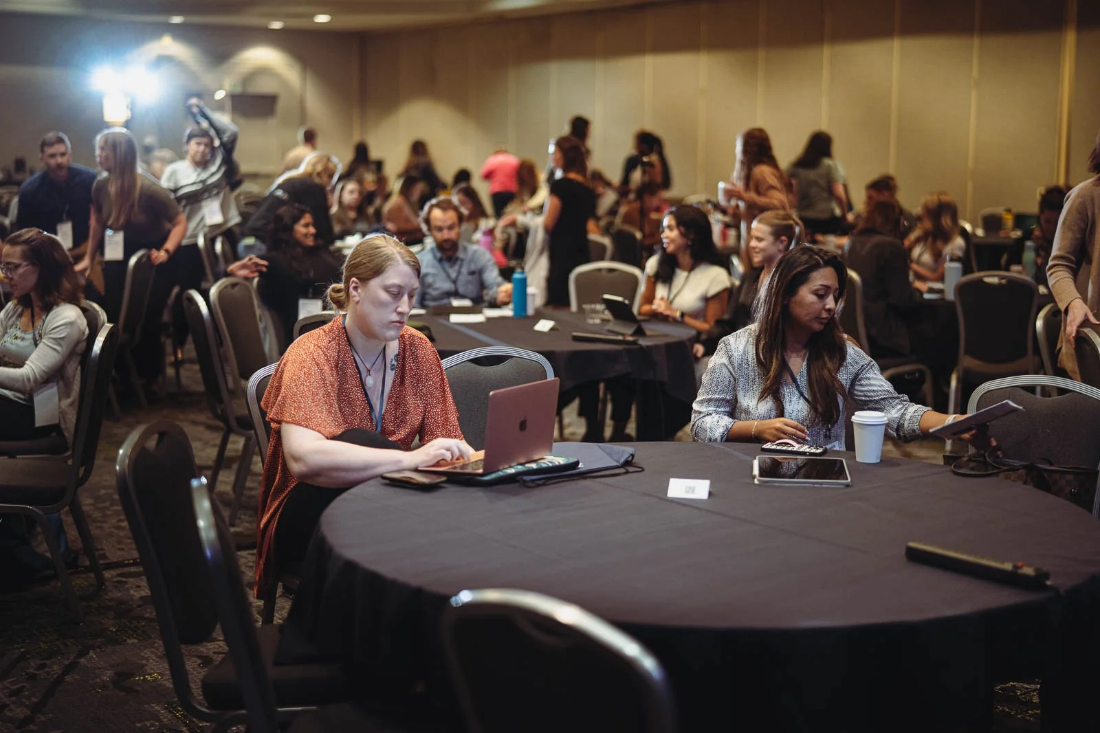 Groups of people around tables in a conference hall