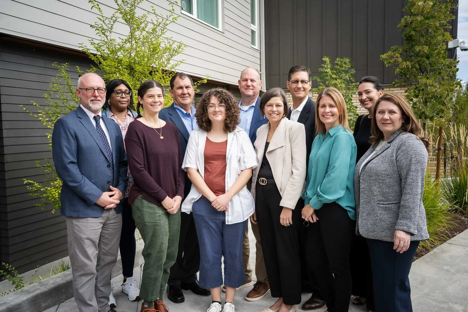 A large group of pose for a photo at the opening of an affordable housing project