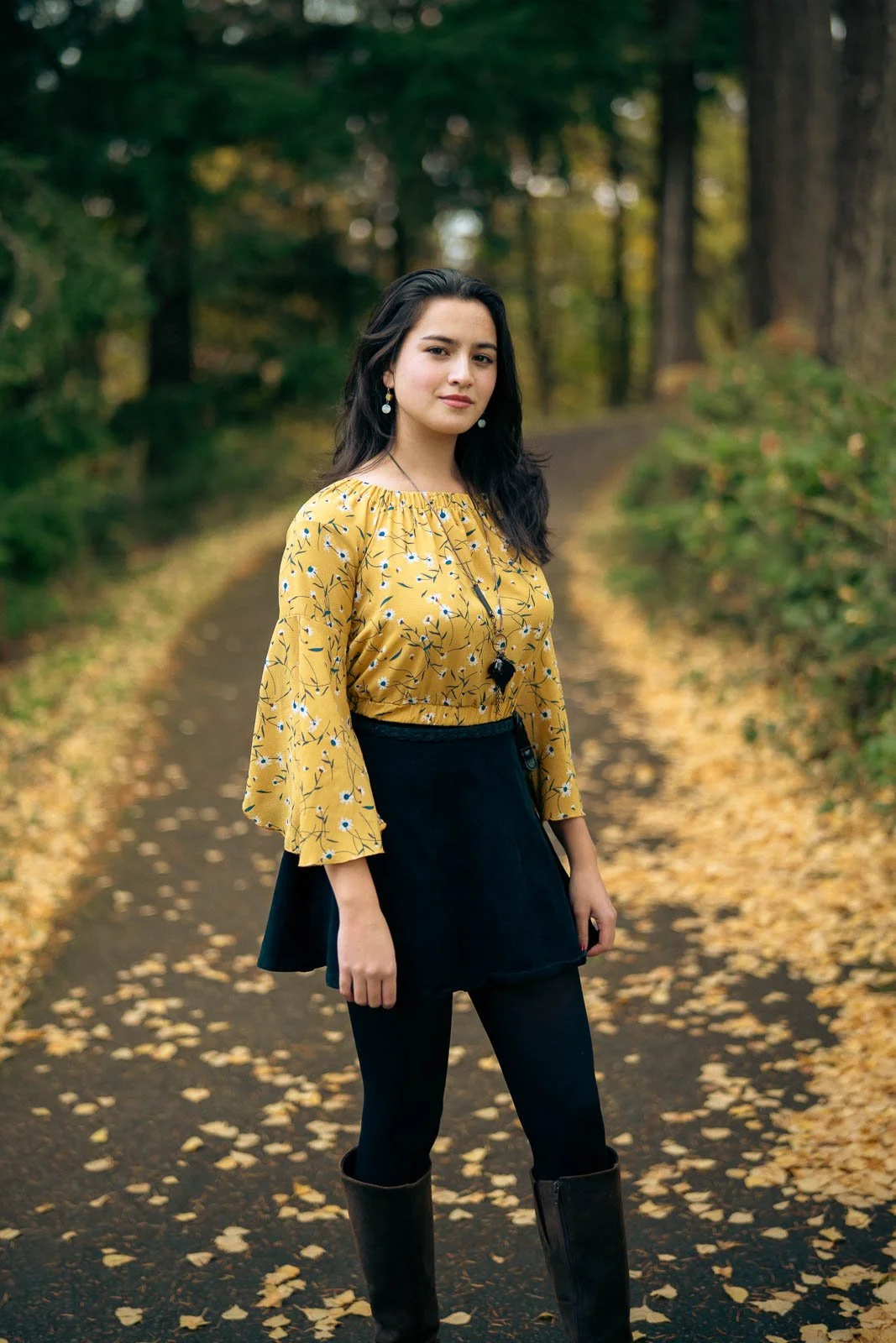 Highschool senior on a path in a park surrounded by fall colors