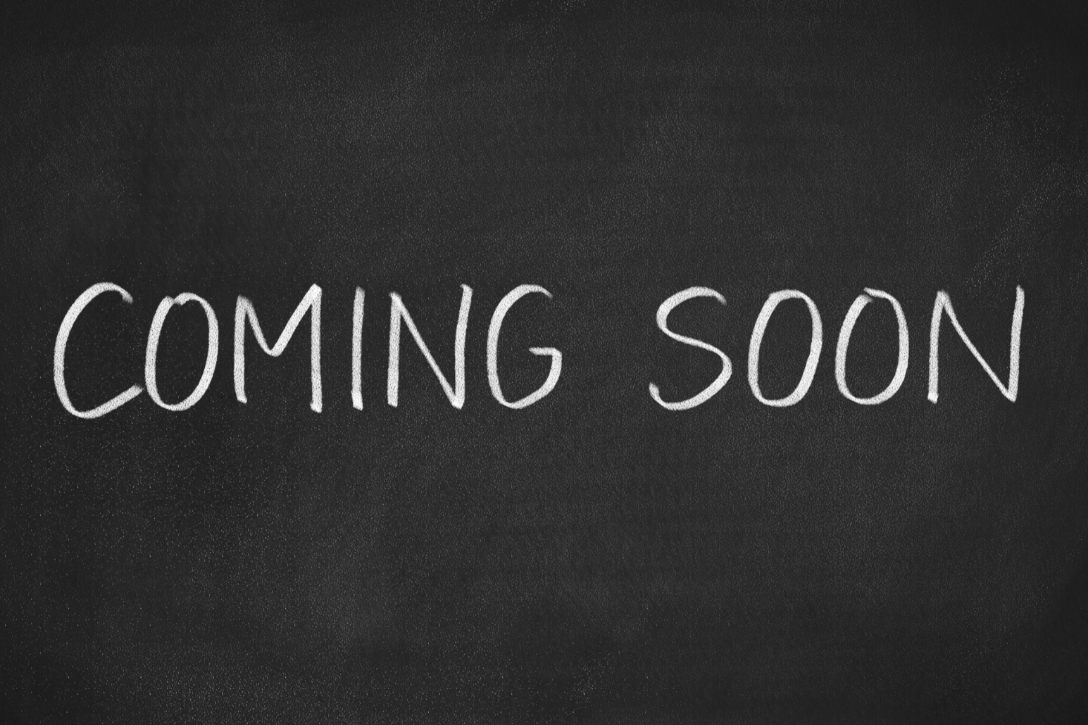 A chalkboard with the words "Coming Soon" written in white chalk.