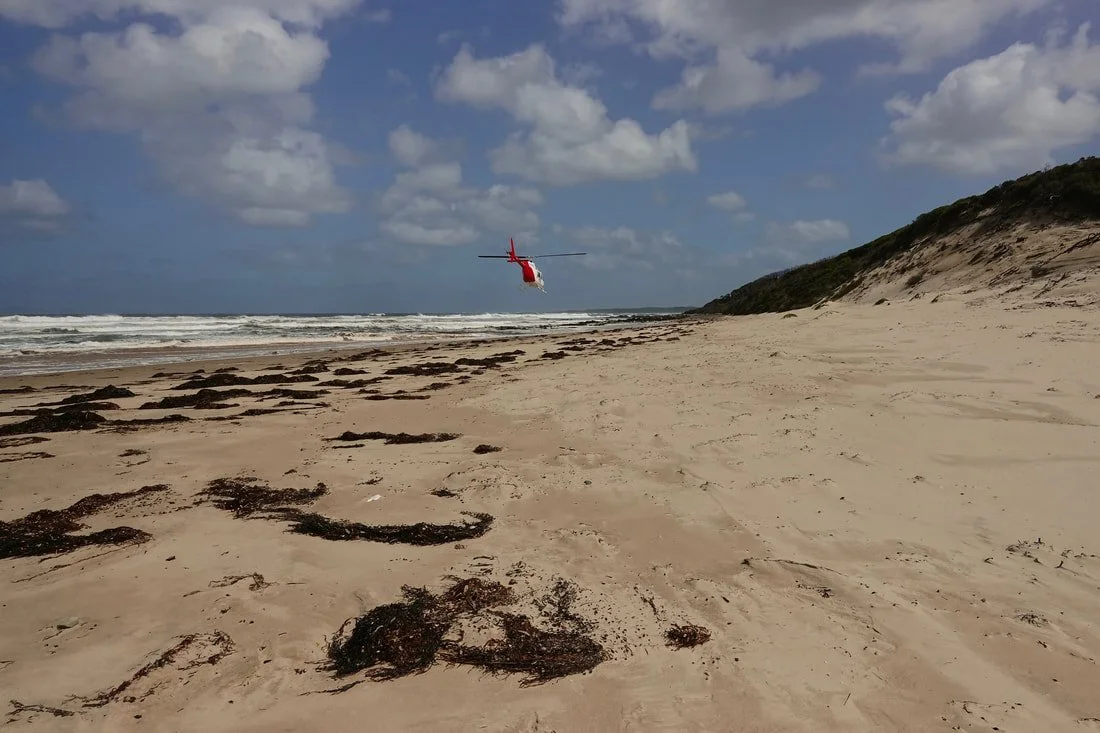 Helicopter lift over Christmas Cove in Tasmania