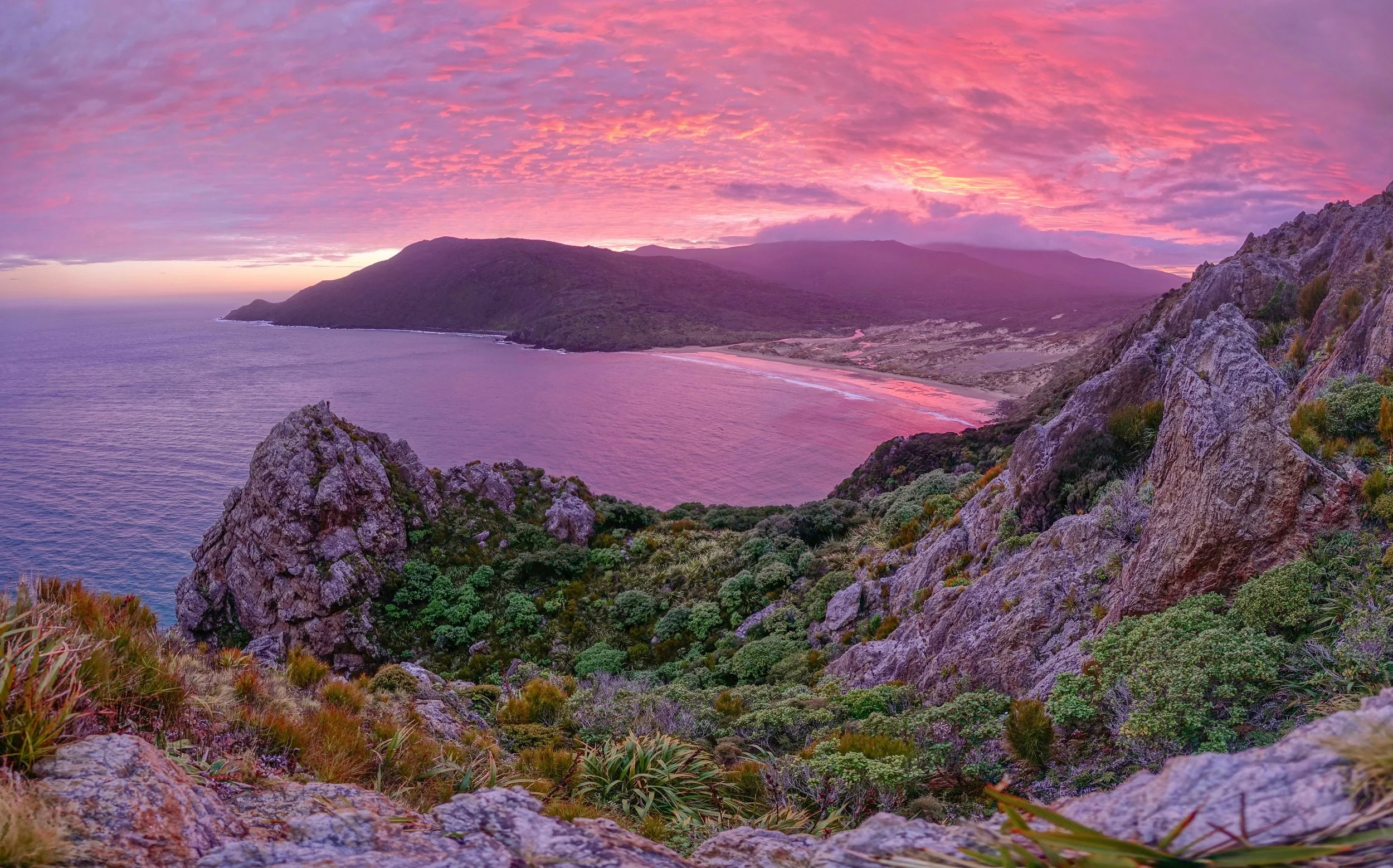 Sunrise above East Ruggedy Beach on Northwest Circuit hike on Stewart Island in New Zealand