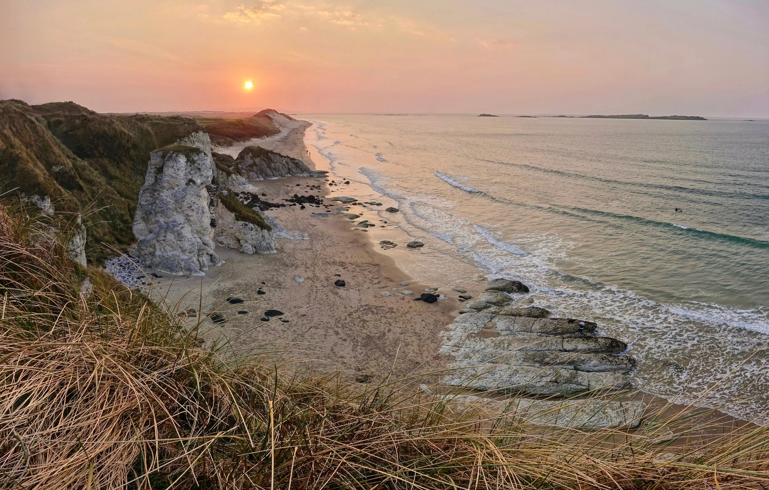 Causeway Coast Way hike in North Ireland along White Rocks beach near Portrush at sunset