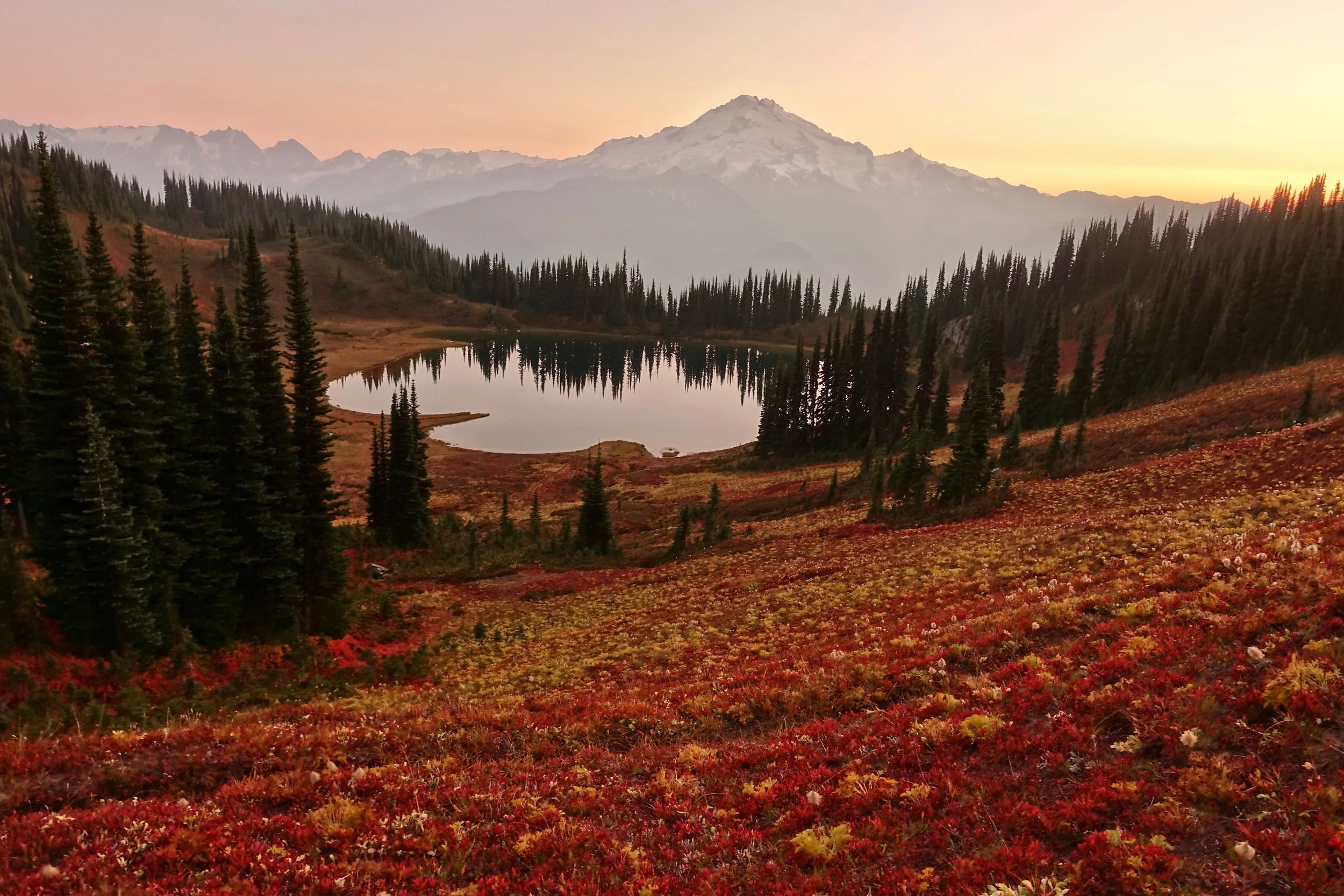 Fall colors over a smoky Image Lake with a view of Glacier Peak in October Washington