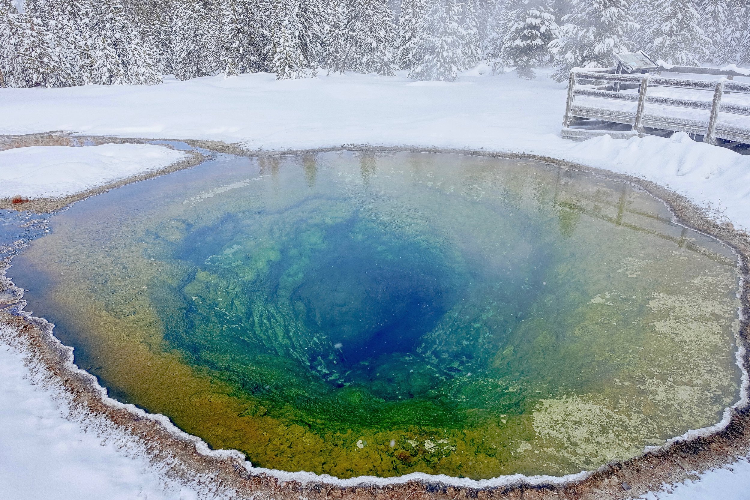 Colored Pool in Old Faithful in snowy winter visit to Yellowstone National Park in Wyoming