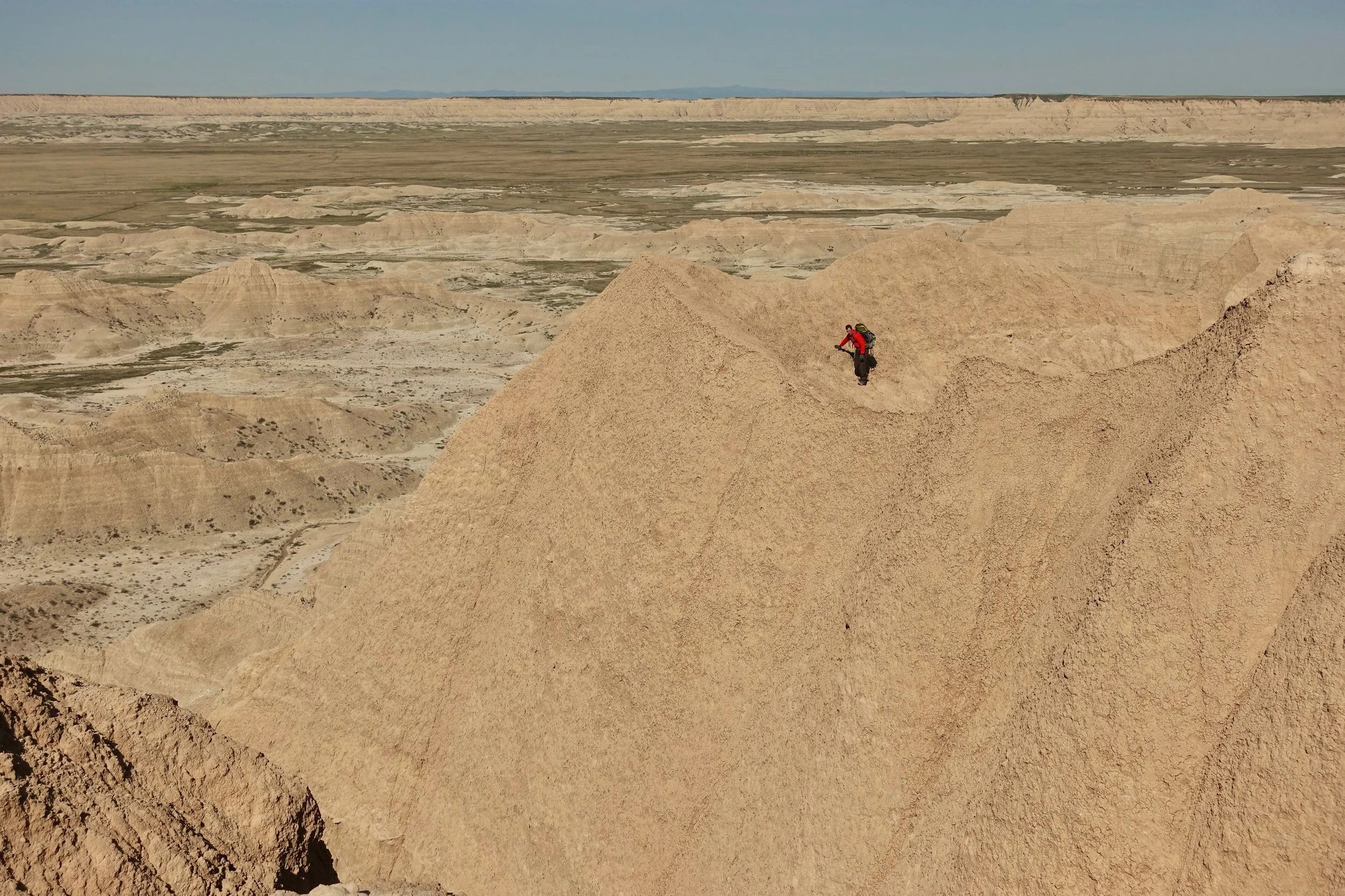 Southwest Sage Creek, hiker on a ledge in Badlands National Park