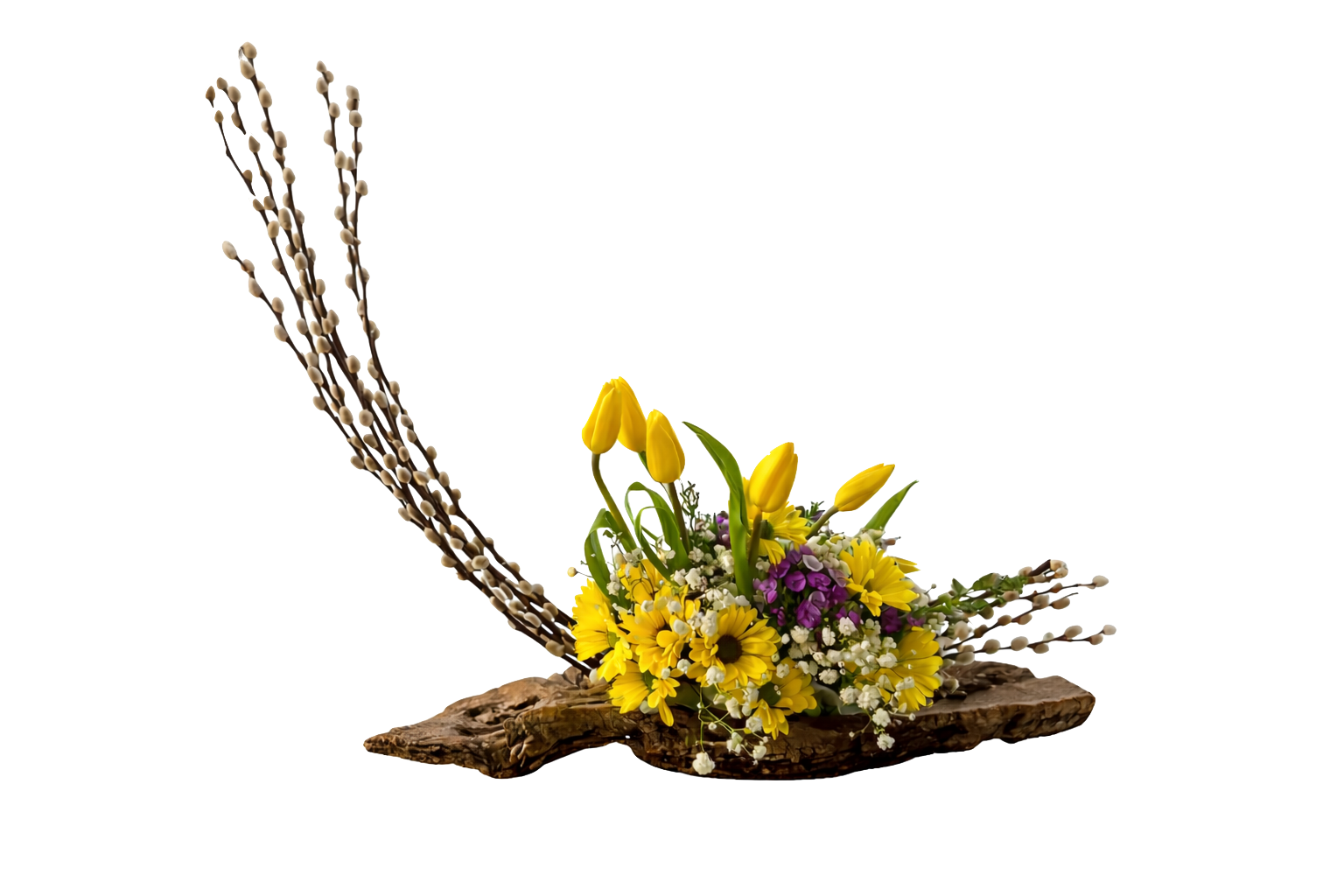 A floral arrangement with yellow tulips, daisies, purple flowers, white baby's breath, and decorative branches on a wooden base.