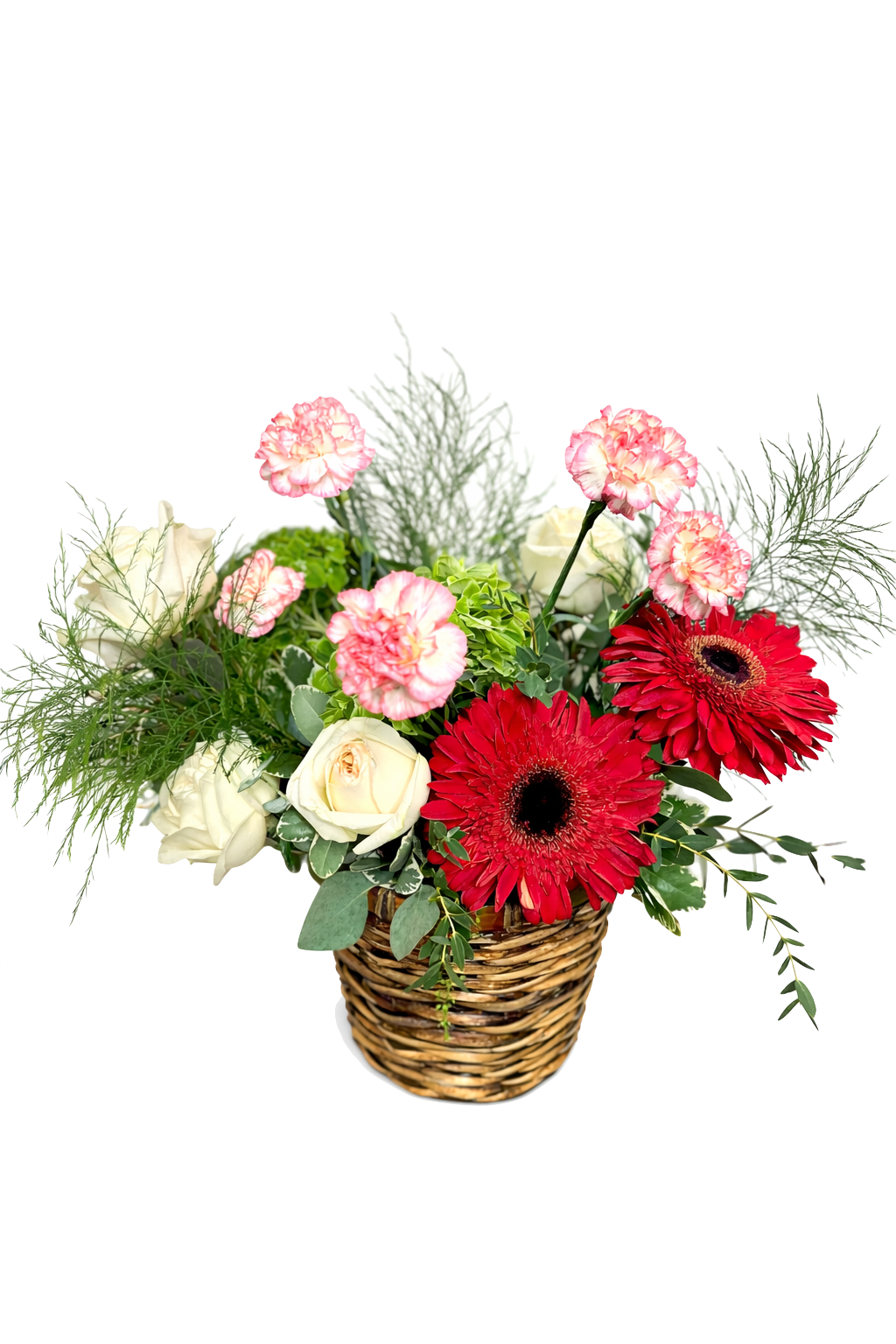 A red and pink based bouquet of mixed flowers in a wicker vase, featuring red, cream, and pink blooms with green leaves.