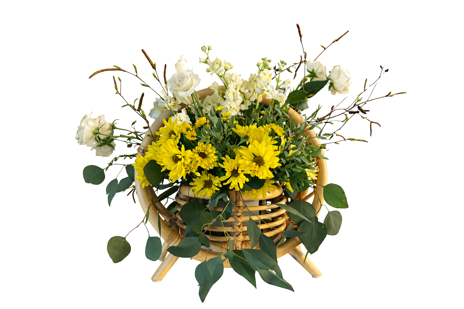 A wicker basket filled with yellow and white flowers, including daisies, roses, hydrangeas, and green leaves, against a plain background.