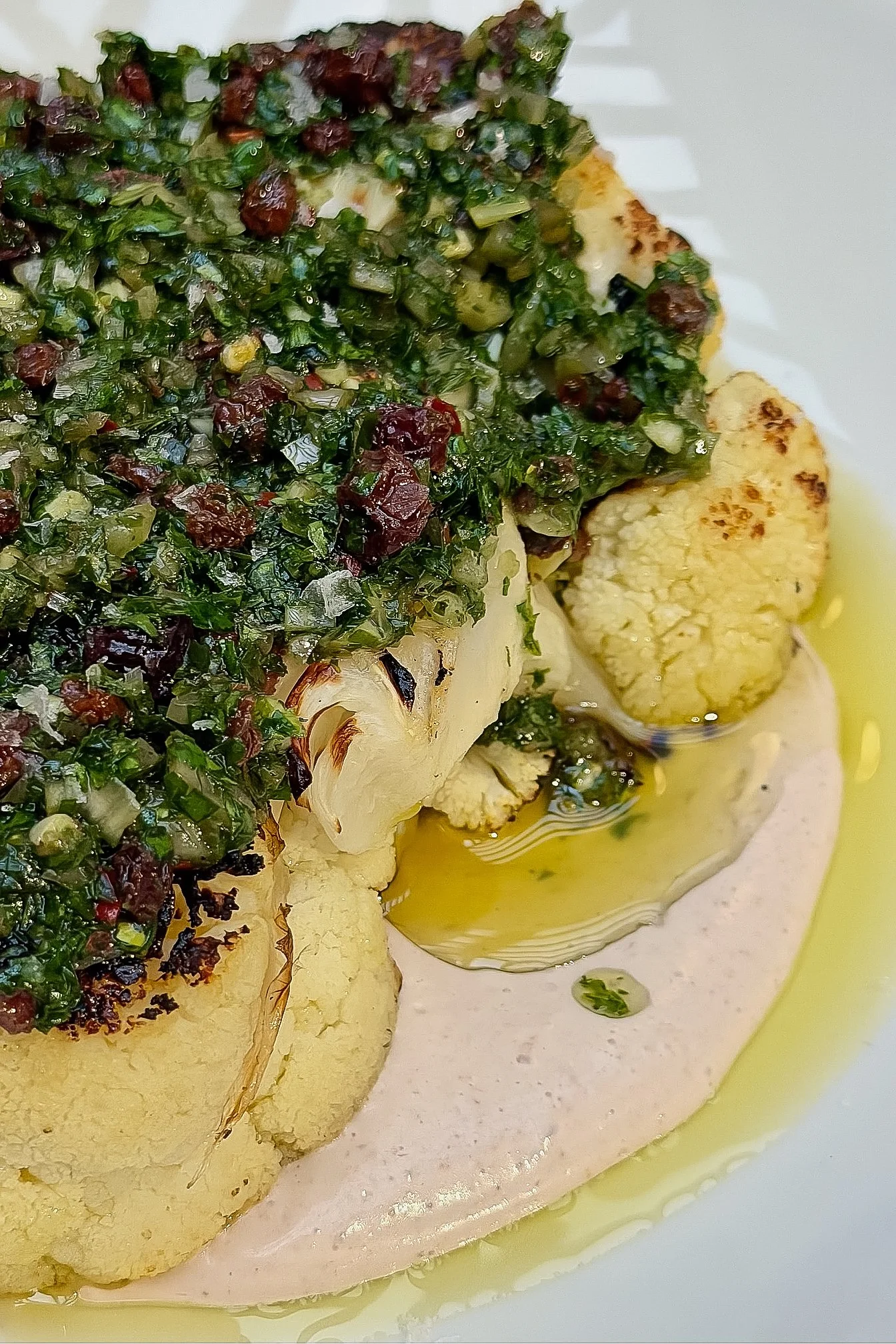 Grilled cauliflower with walnut yogurt and currant-chimichurri, a signature vegetable share at Viv & Jules.