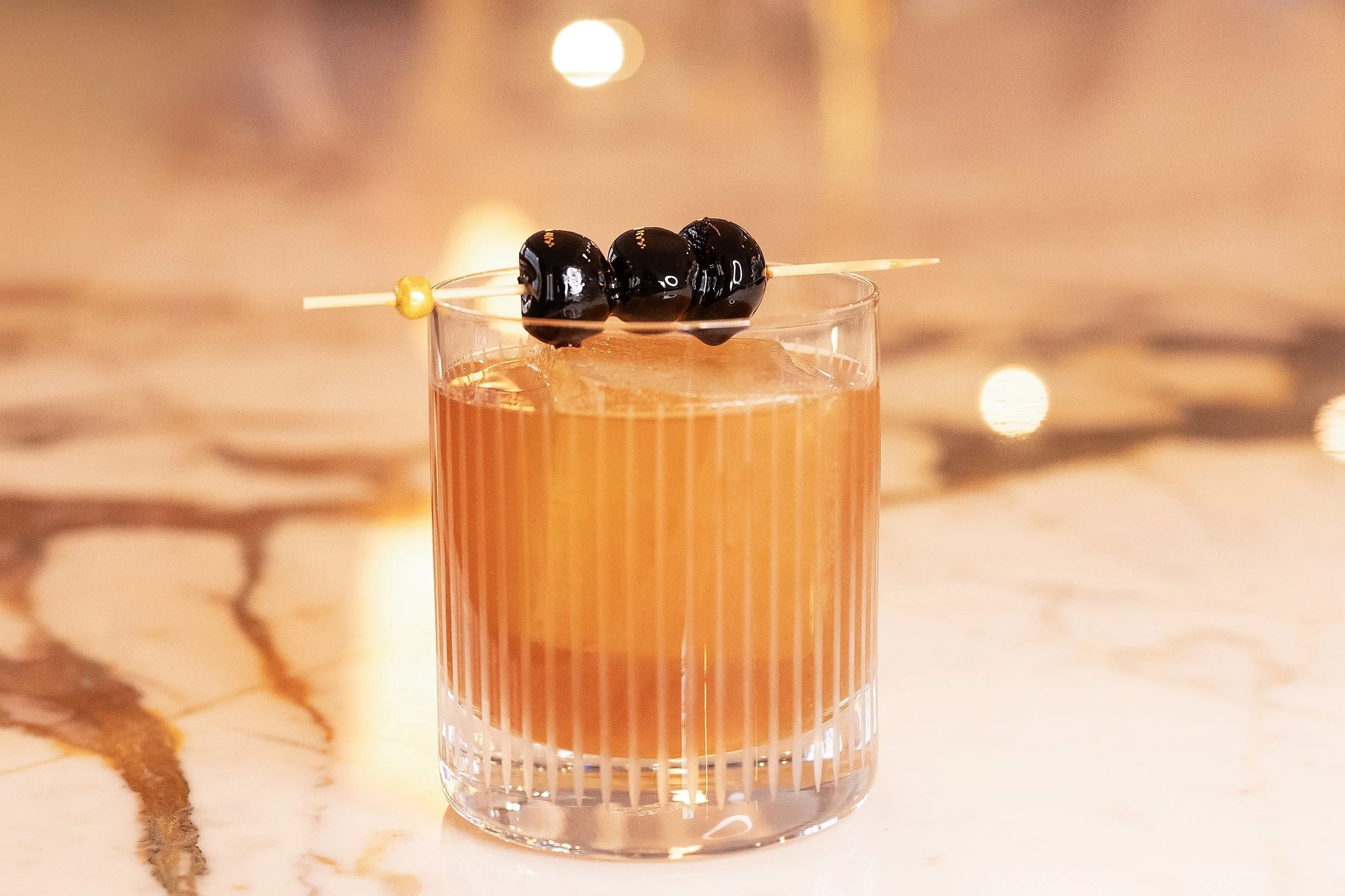 Craft cocktail with dark cherry garnish served in a fluted glass at the Viv & Jules bar in Hoboken.