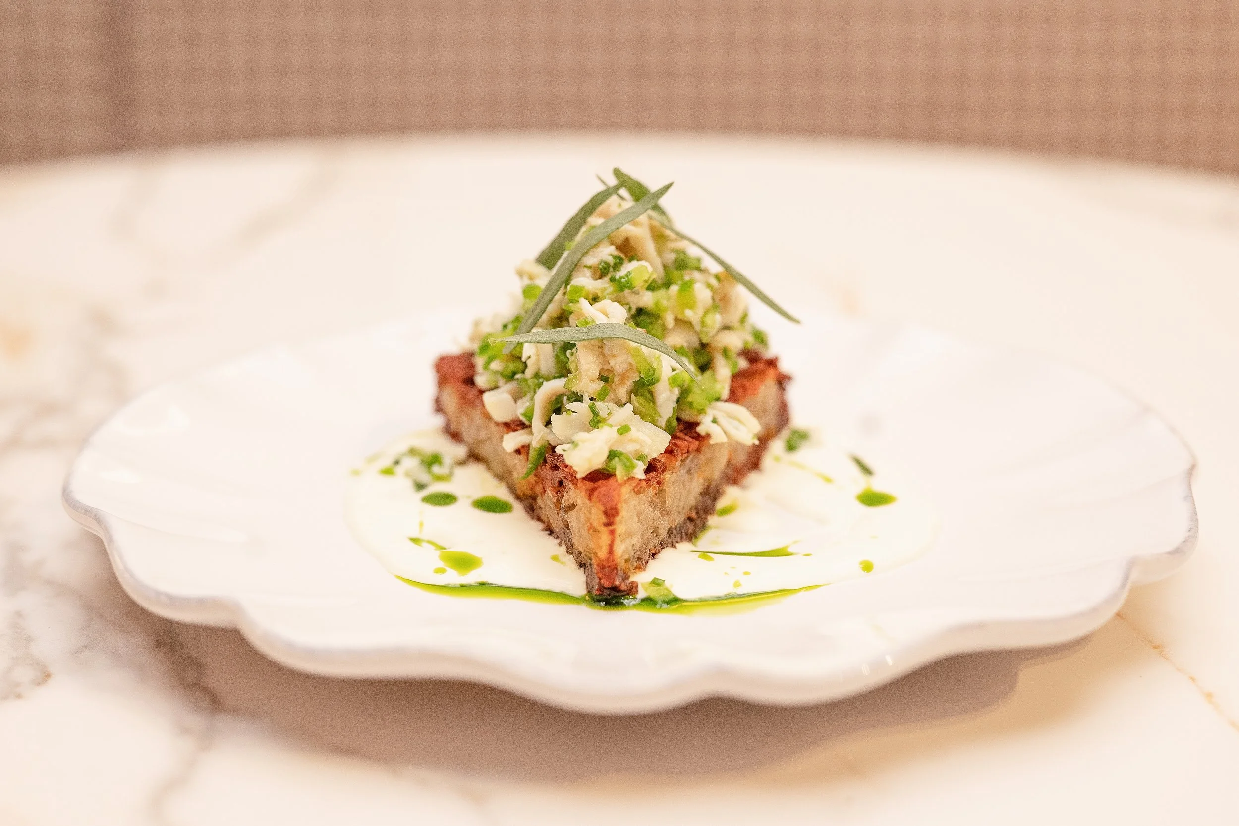 Dungeness Crab Hash Brown with jalapeño, yuzu, and lemon crème fraîche, precision-plated on a scalloped dish at Viv & Jules.