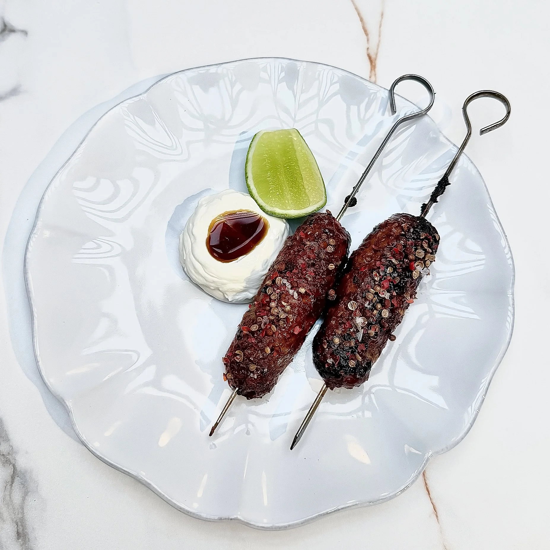 Lamb Tsukune skewers with pomegranate glaze, cracked spices, and a side of yogurt by Chef Cliff Crooks at Viv and Jules Hoboken.