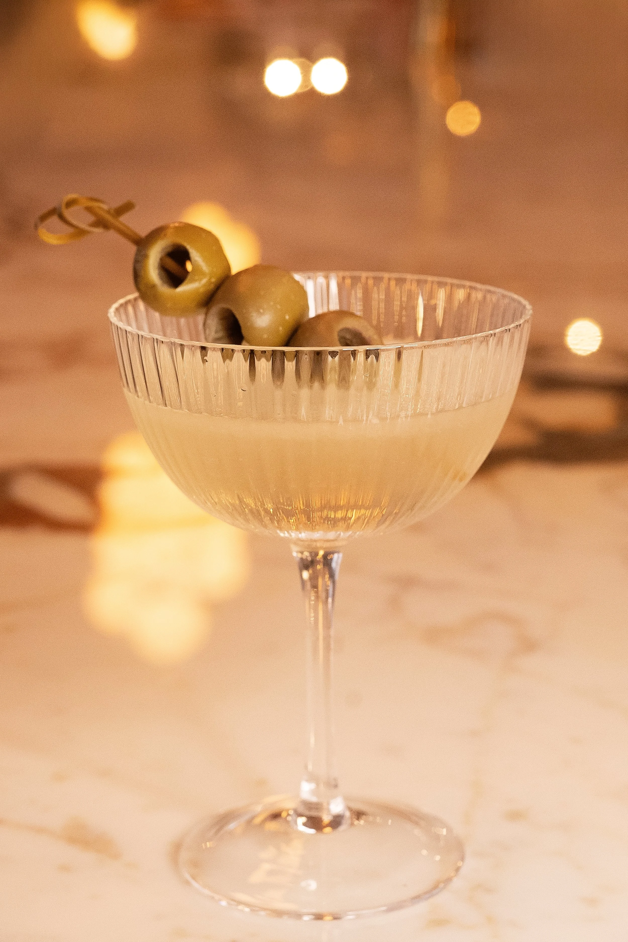 Classic martini with a three-olive garnish served in a fluted glass at Viv & Jules Hoboken.