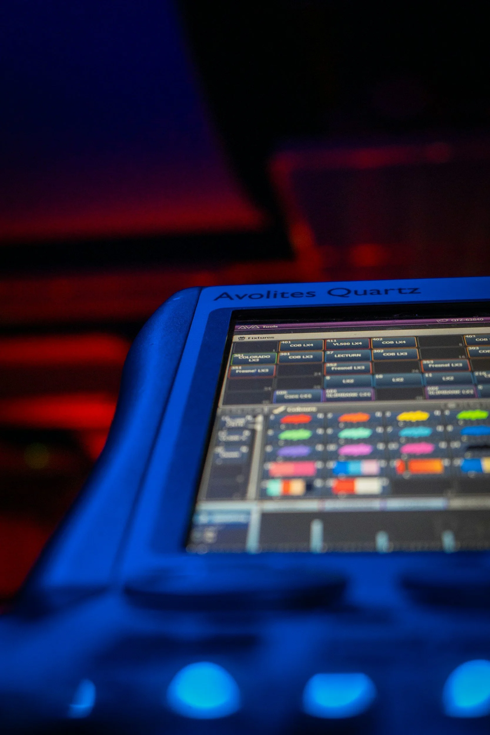 Close-up of electronic music equipment with colorful buttons and a screen displaying a digital audio workstation.