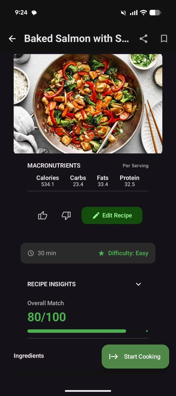 A bowl of baked salmon with vegetables, including red bell peppers, broccoli, and mushrooms, on a dark surface with rice, greens, and chopsticks nearby.