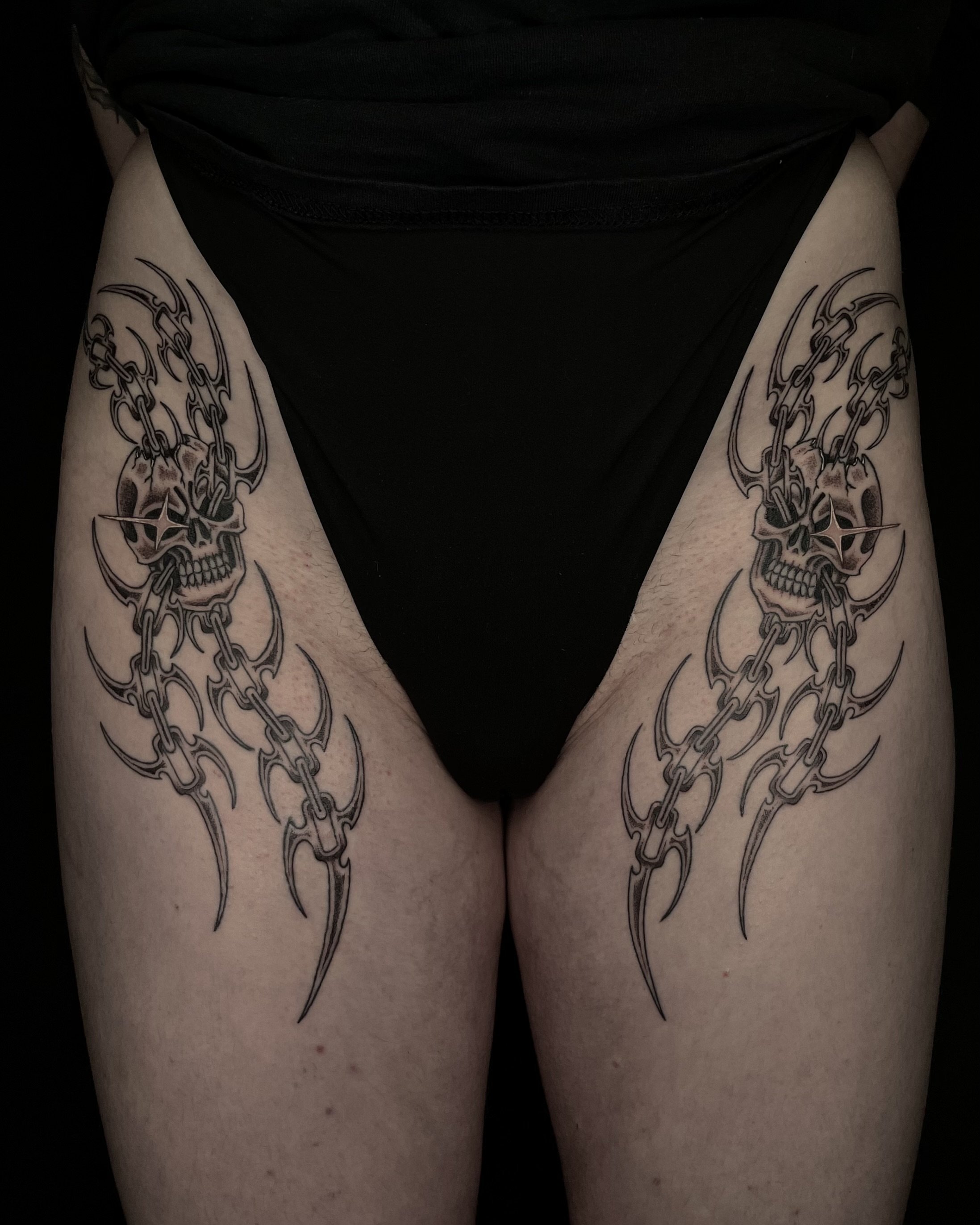 matching skulls and tribal chains tattoo