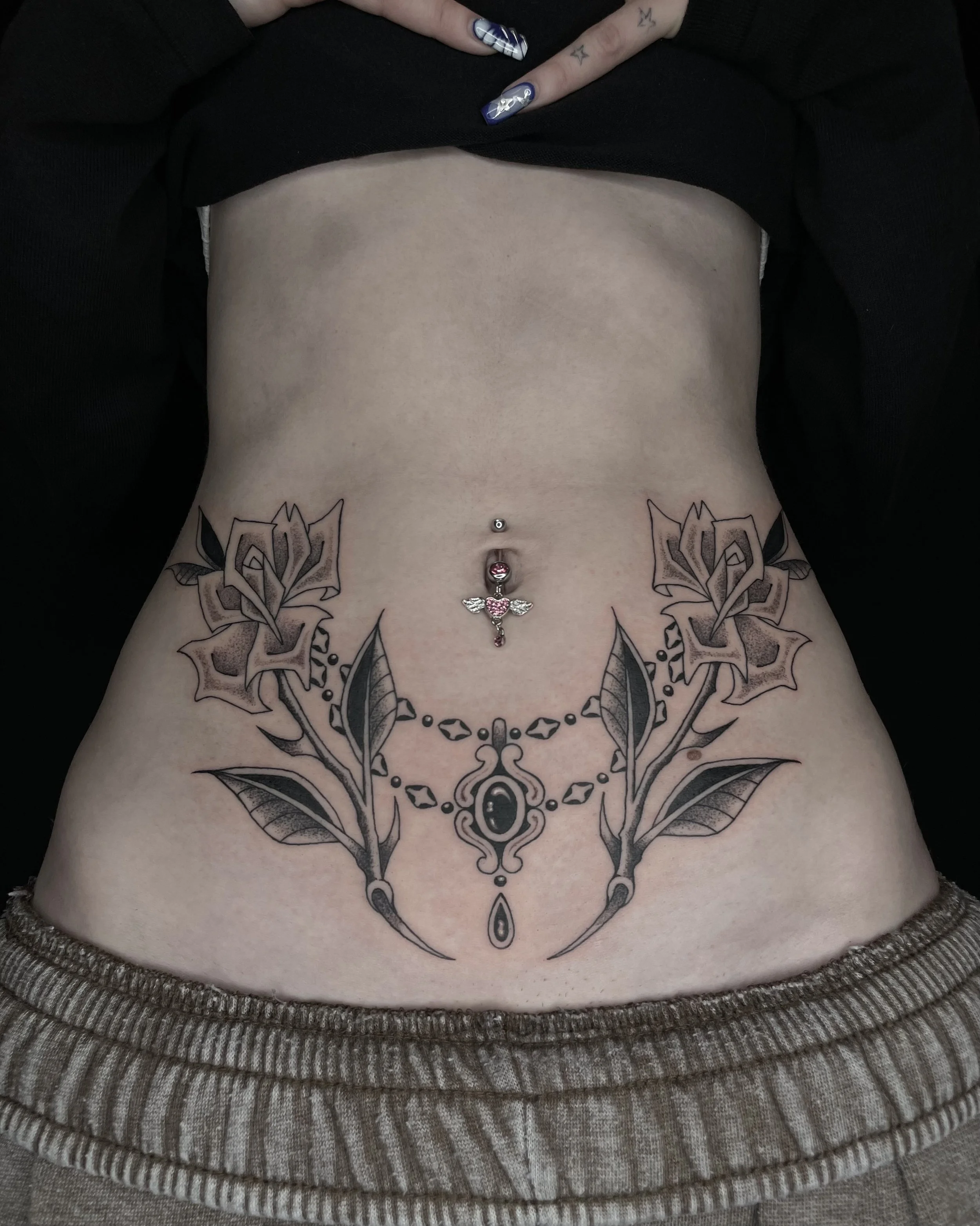 matching roses and jewelry stomach tattoo
