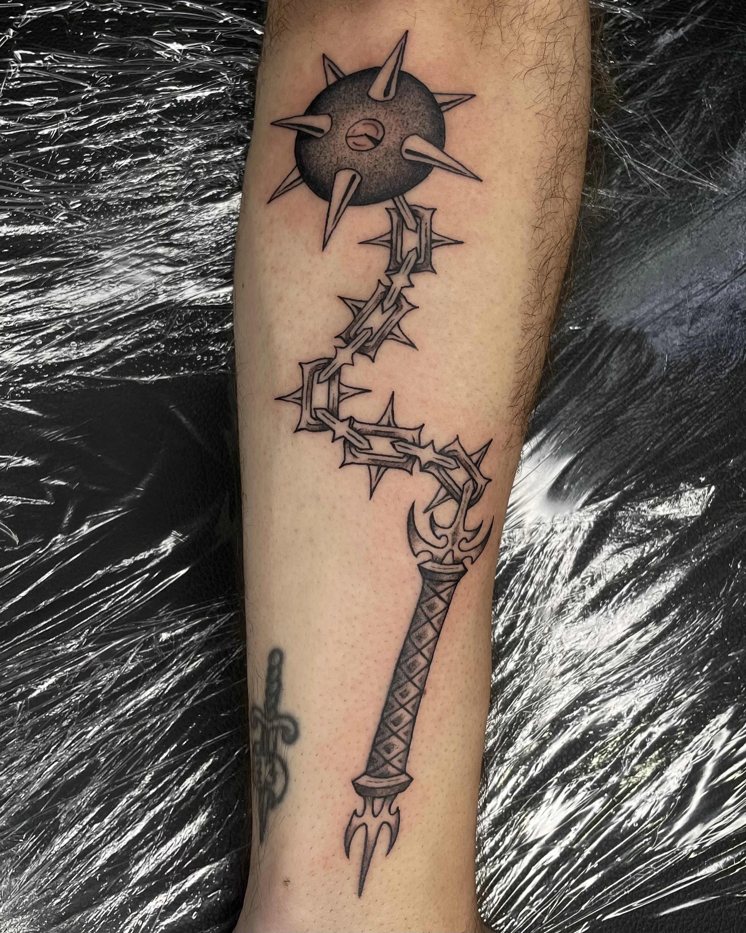 black and grey flail tattoo
