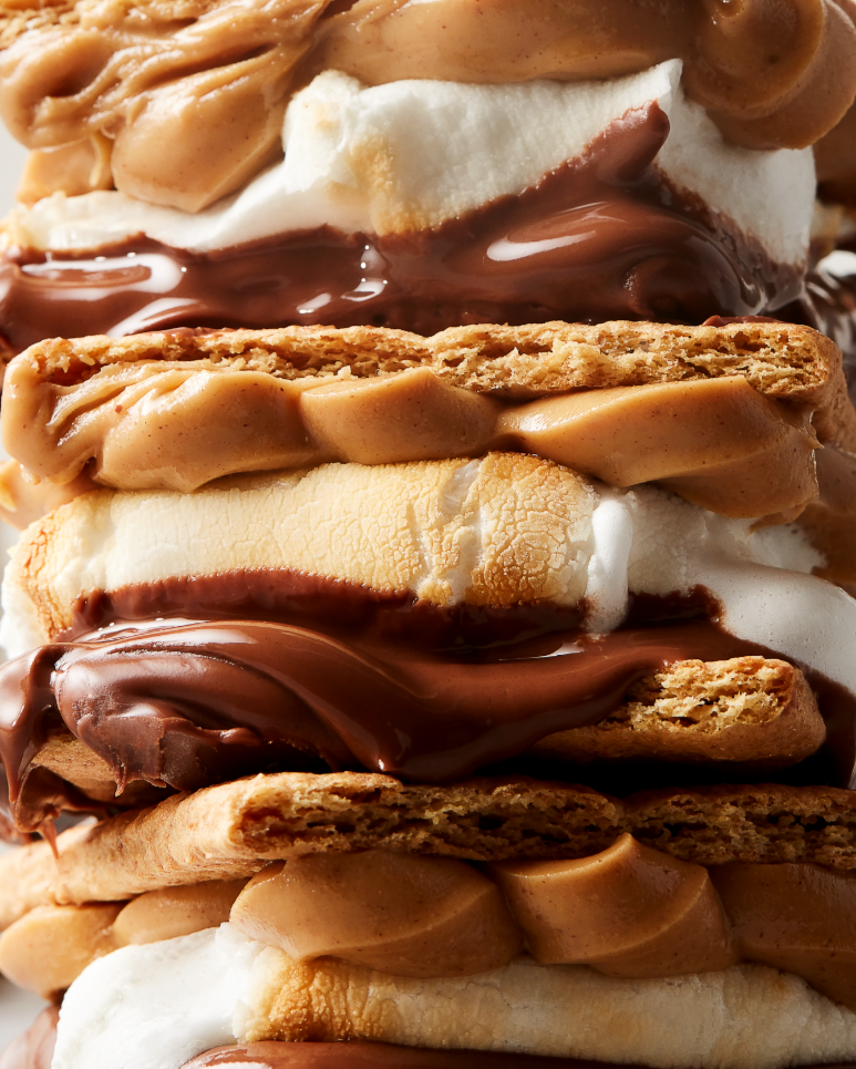 Close-up of a s'mores-inspired dessert with layers of graham crackers, marshmallow, chocolate, and peanut butter.