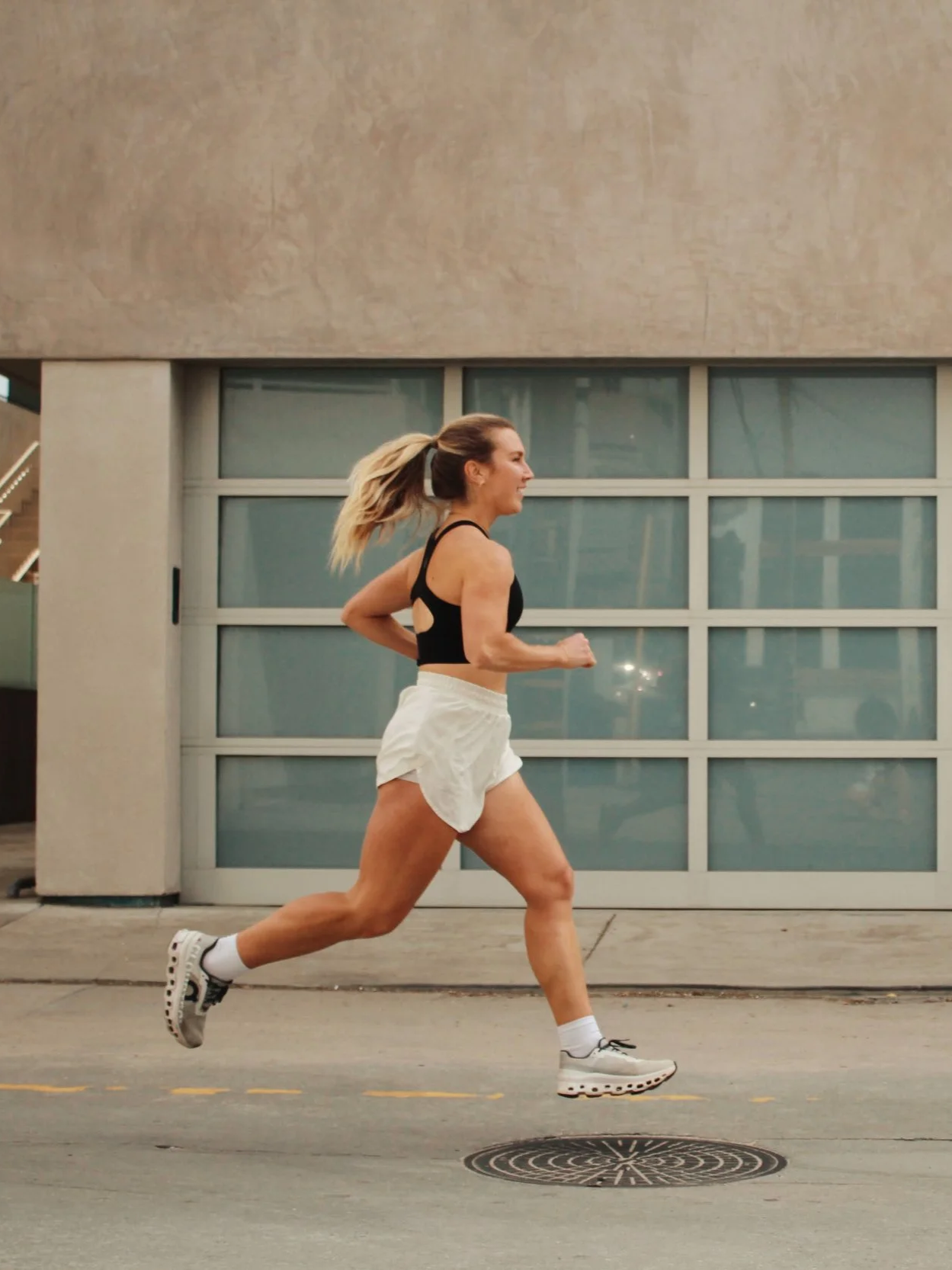 Woman running outdoors on city street during daytime.