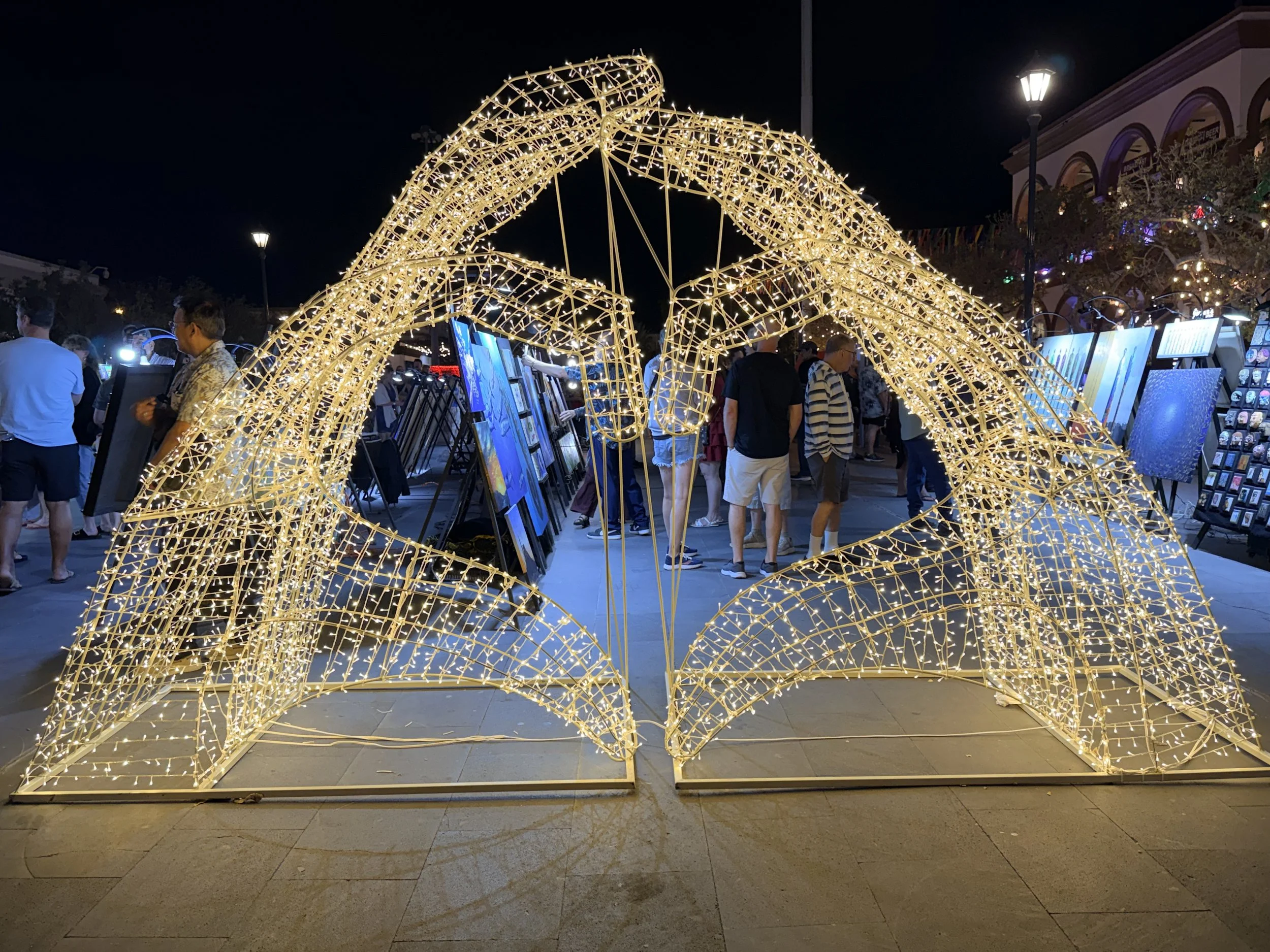 Stunning golden wire arch light sculpture illuminated at night, showcasing creative event lighting and design inspiration from Obsidian Opal Events