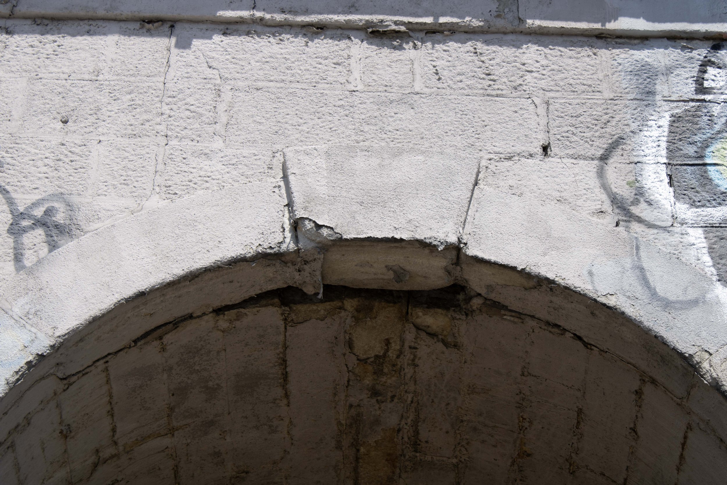 Exterior condition shot, plaster and keystone seen separating from primary facade.