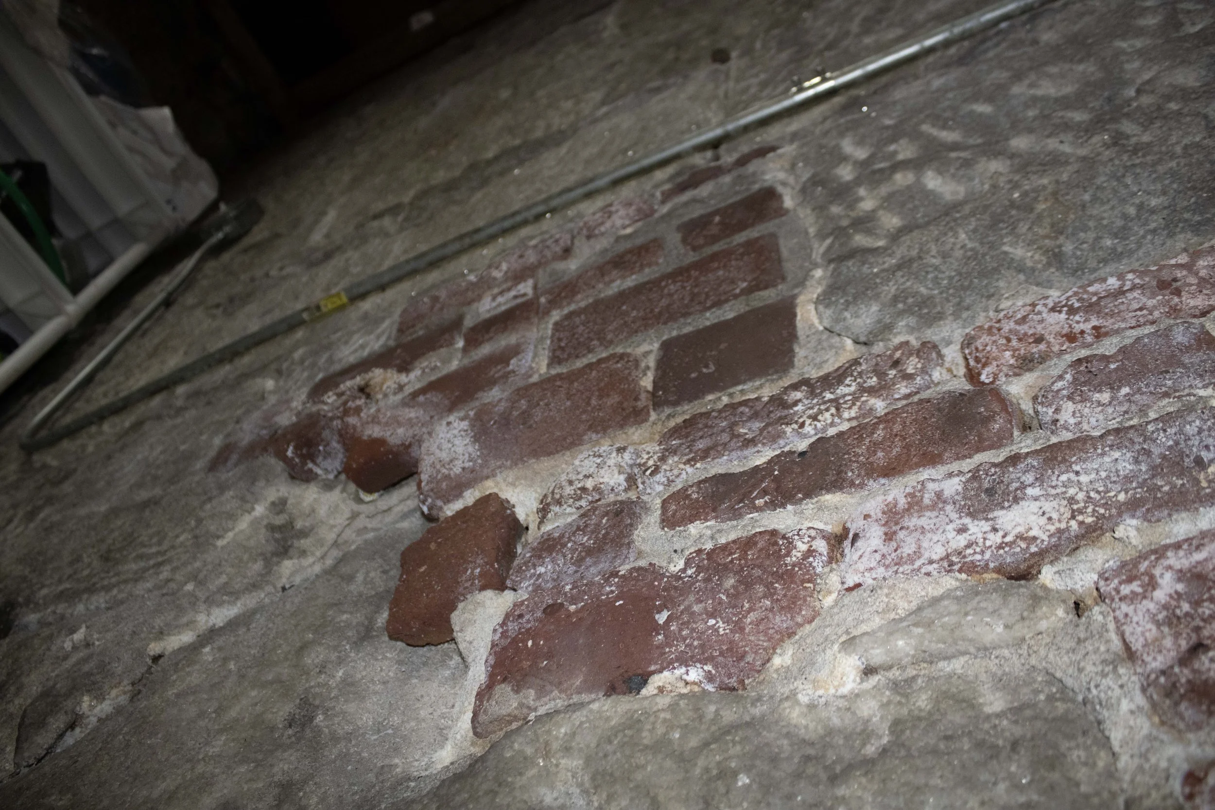 In-situ brick repair within the marble walls.