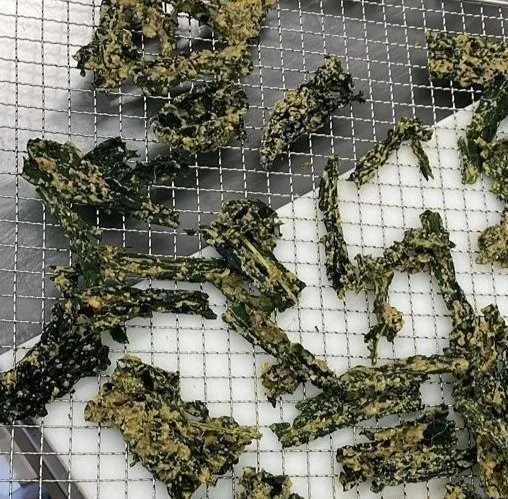 Dried or roasted seaweed snack pieces on a wire cooling rack.